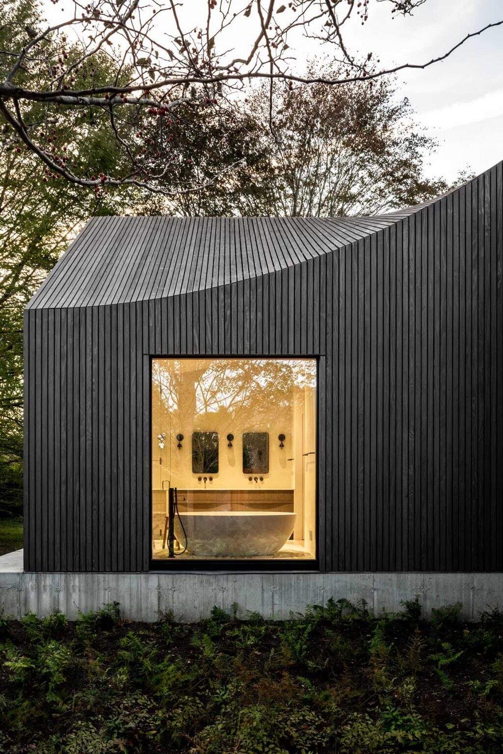 An undulating roofline flows across six connected volumes, creating dynamic angles and ever-changing views throughout the home.