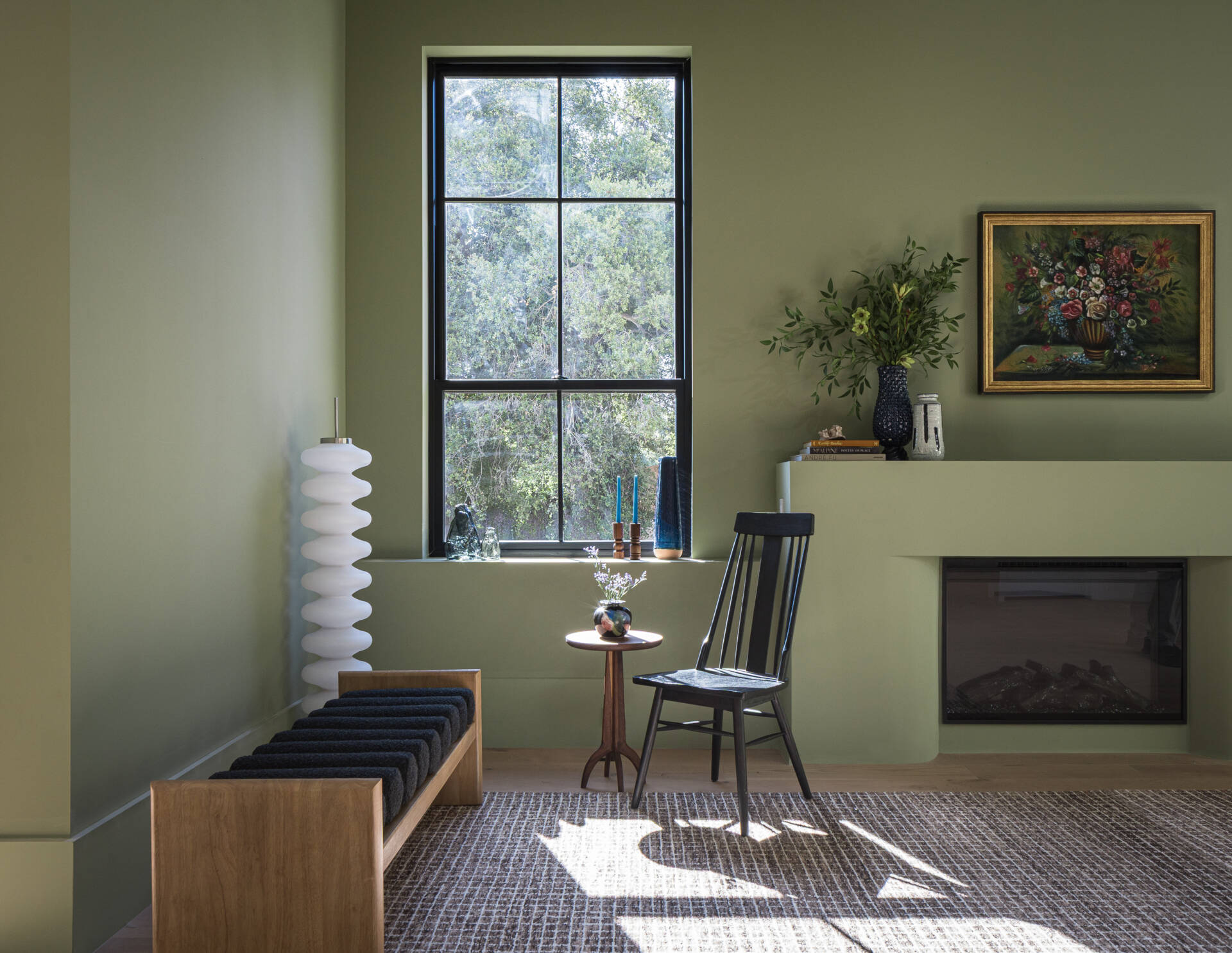 Instead of a fully open layout, the home uses distinct rooms that still feel visually linked. A sitting room opposite the bench is one of these spaces, offering a quieter setting while maintaining connection to the rest of the main level.