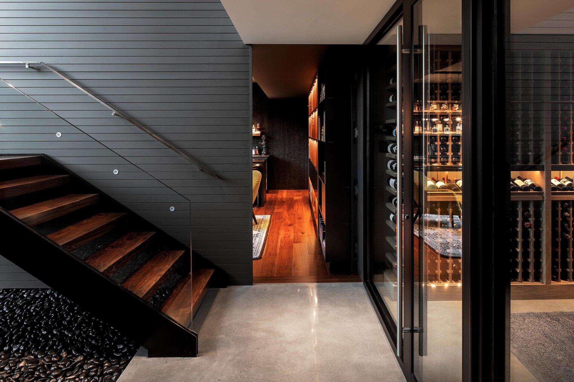 A modern home with a hidden whiskey room behind a bookshelf and a full entertainment wing including a gym, sauna, and media room.