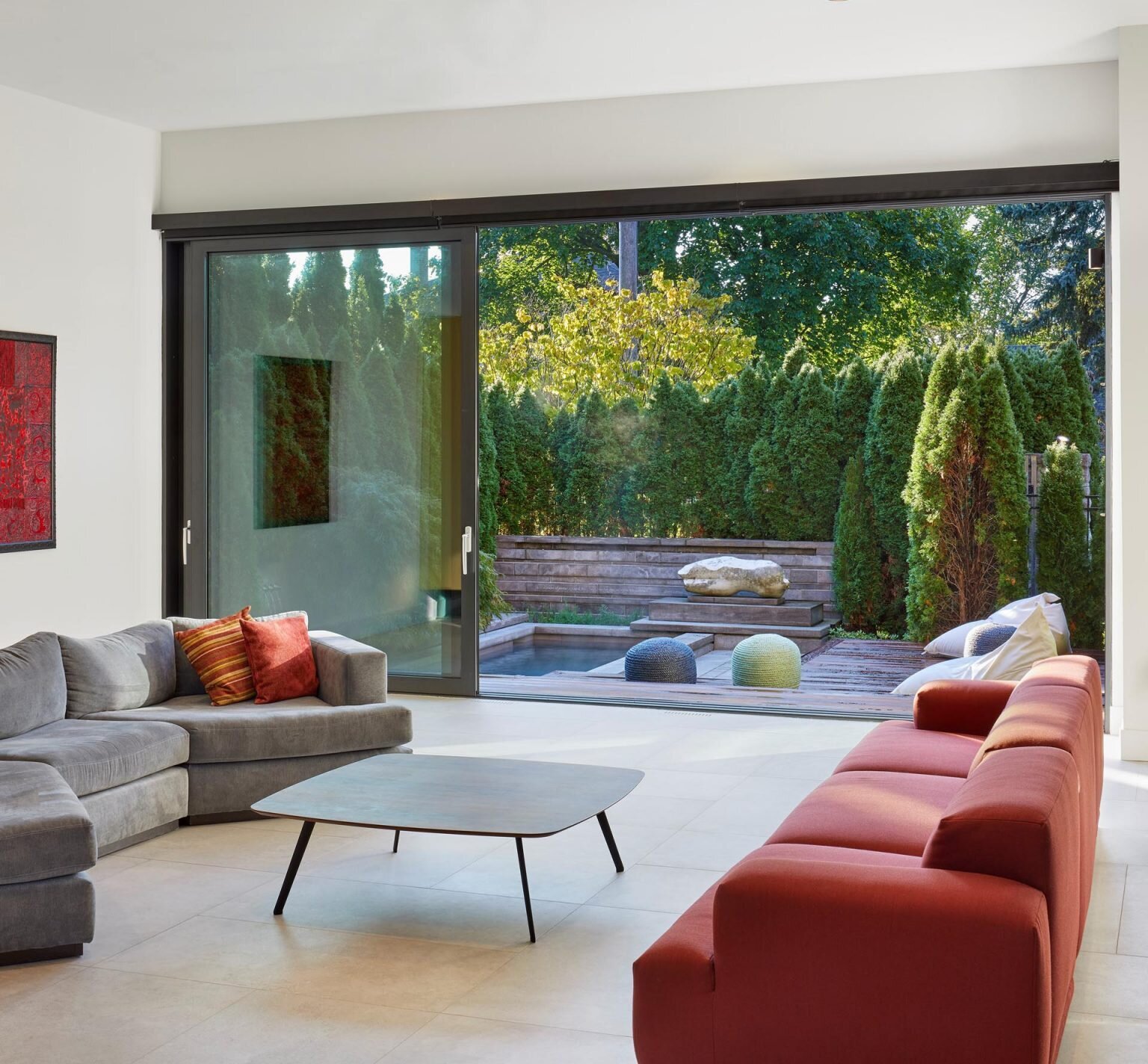 Large sliding glass doors connect the living room to the courtyard, blending indoor and outdoor spaces.