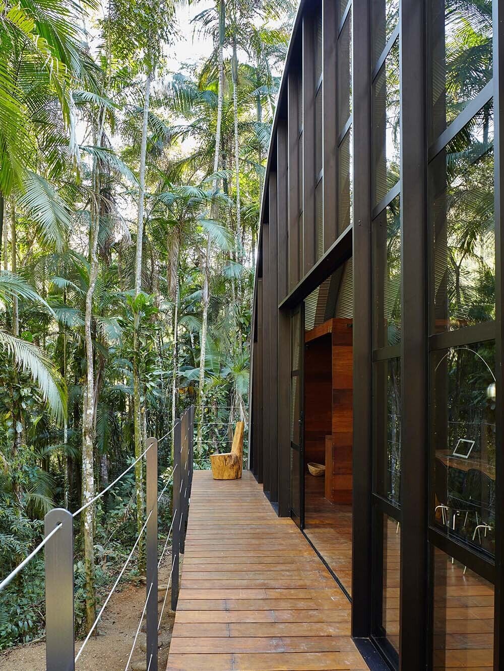 A simple timber deck extends the living space outward, creating a seamless connection between the home and the forest.