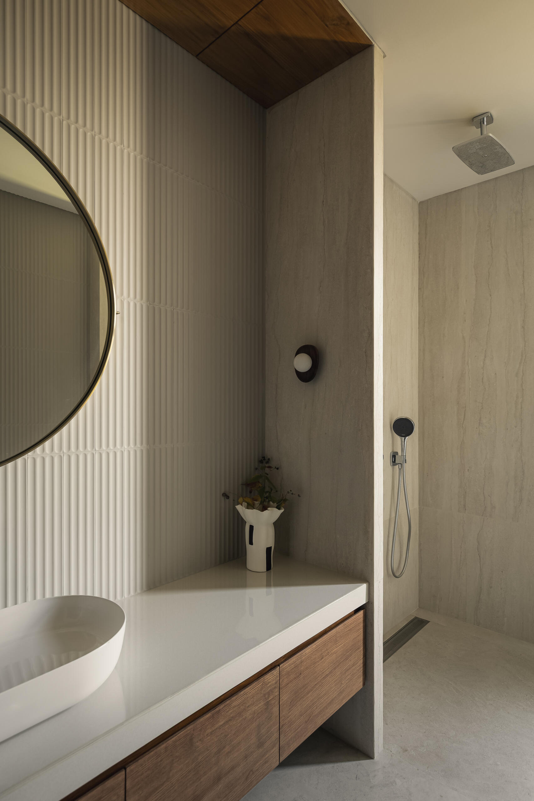 A modern bathroom with neutral finished and a wood vanity accent.