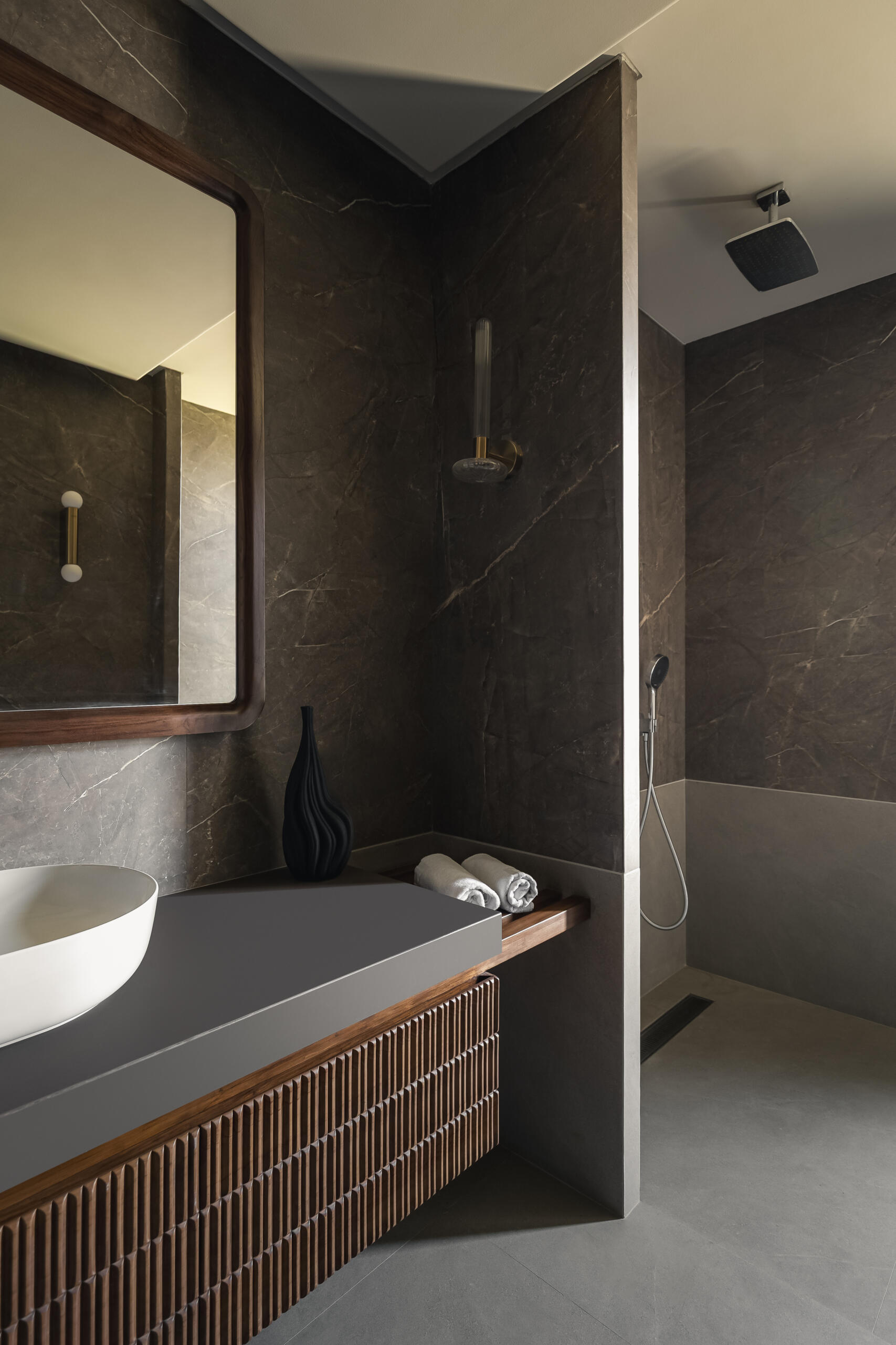 A modern bathroom with a wood and grey color palette.