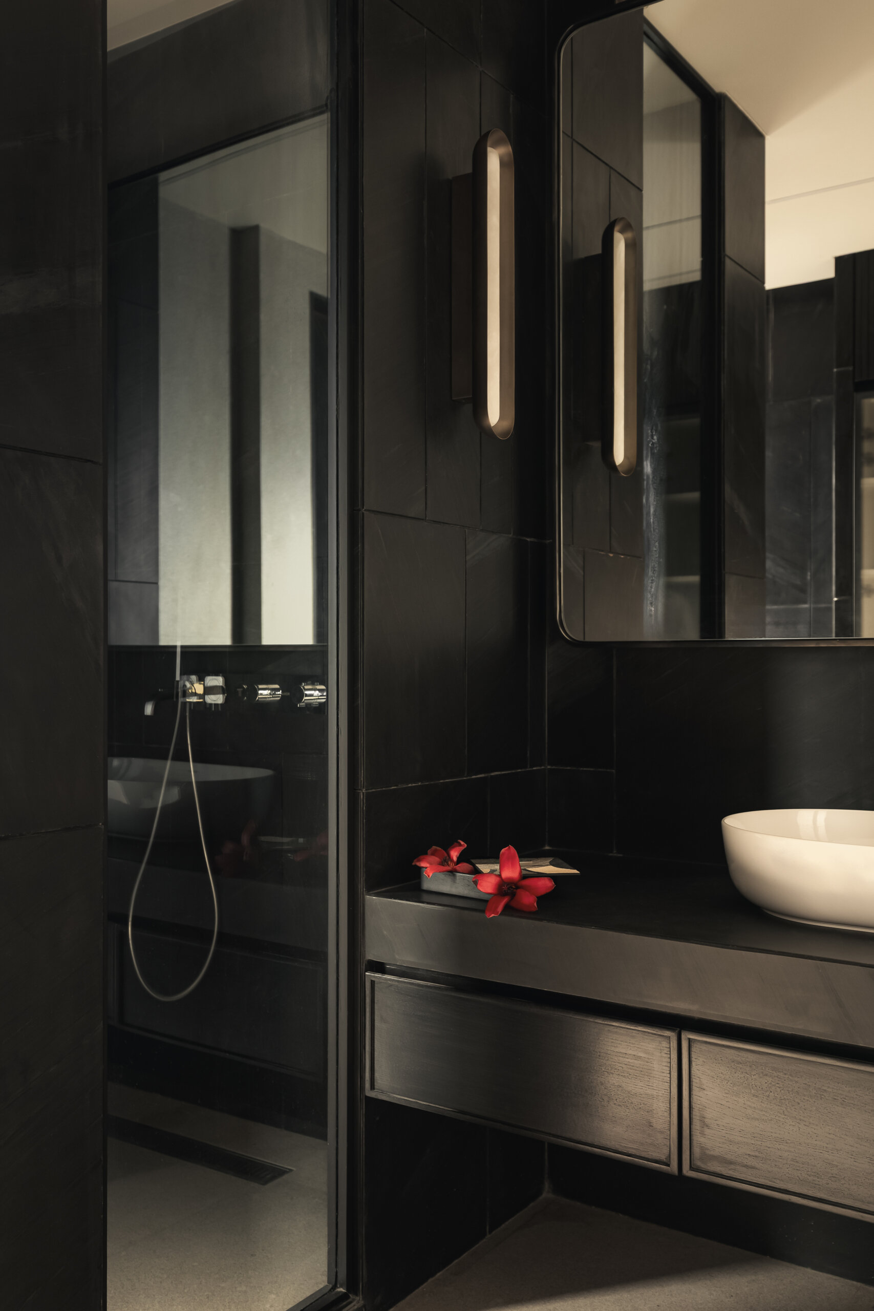 A modern bathroom with dark finishes.