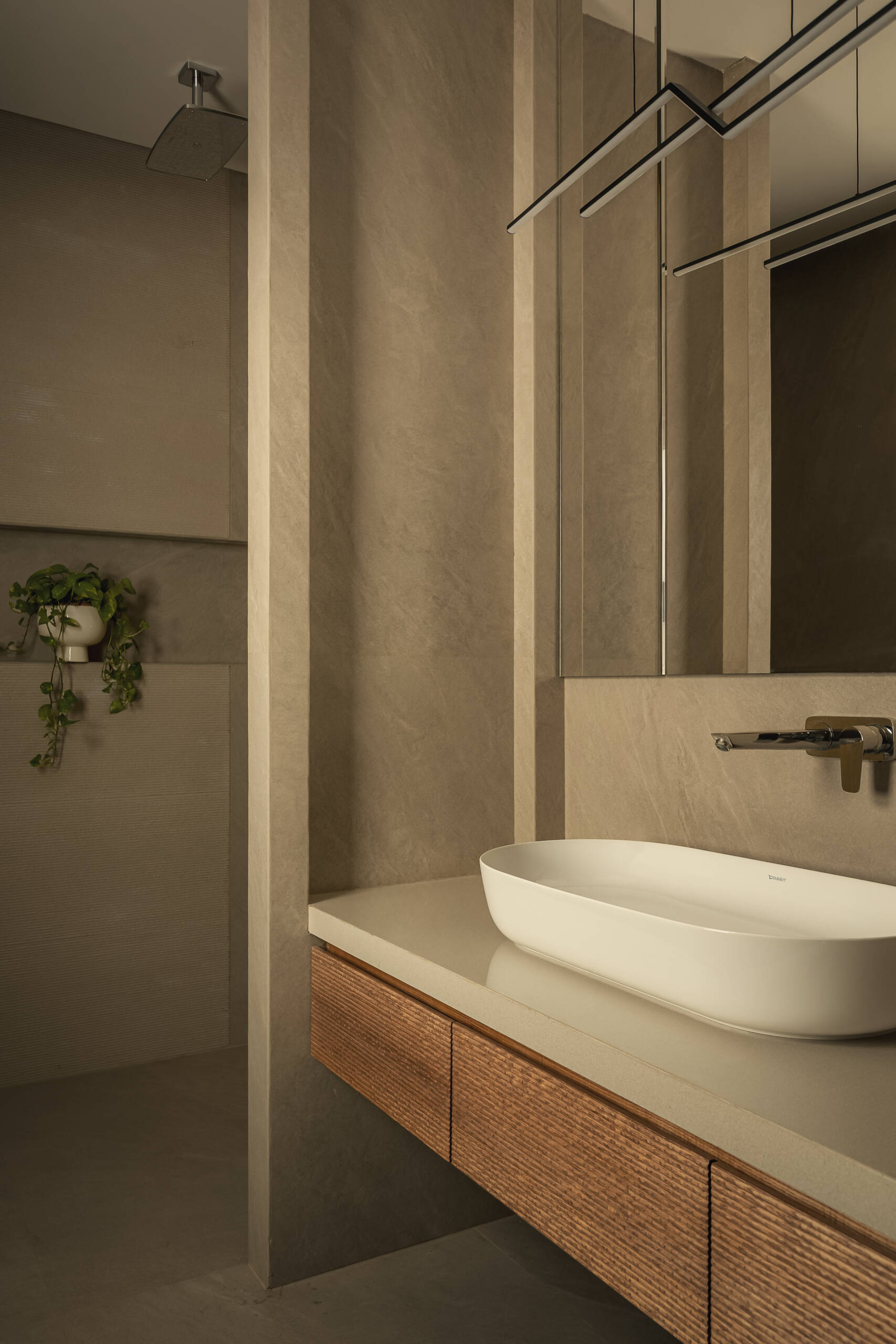 A modern bathroom with neutral tones and a floating wood vanity.