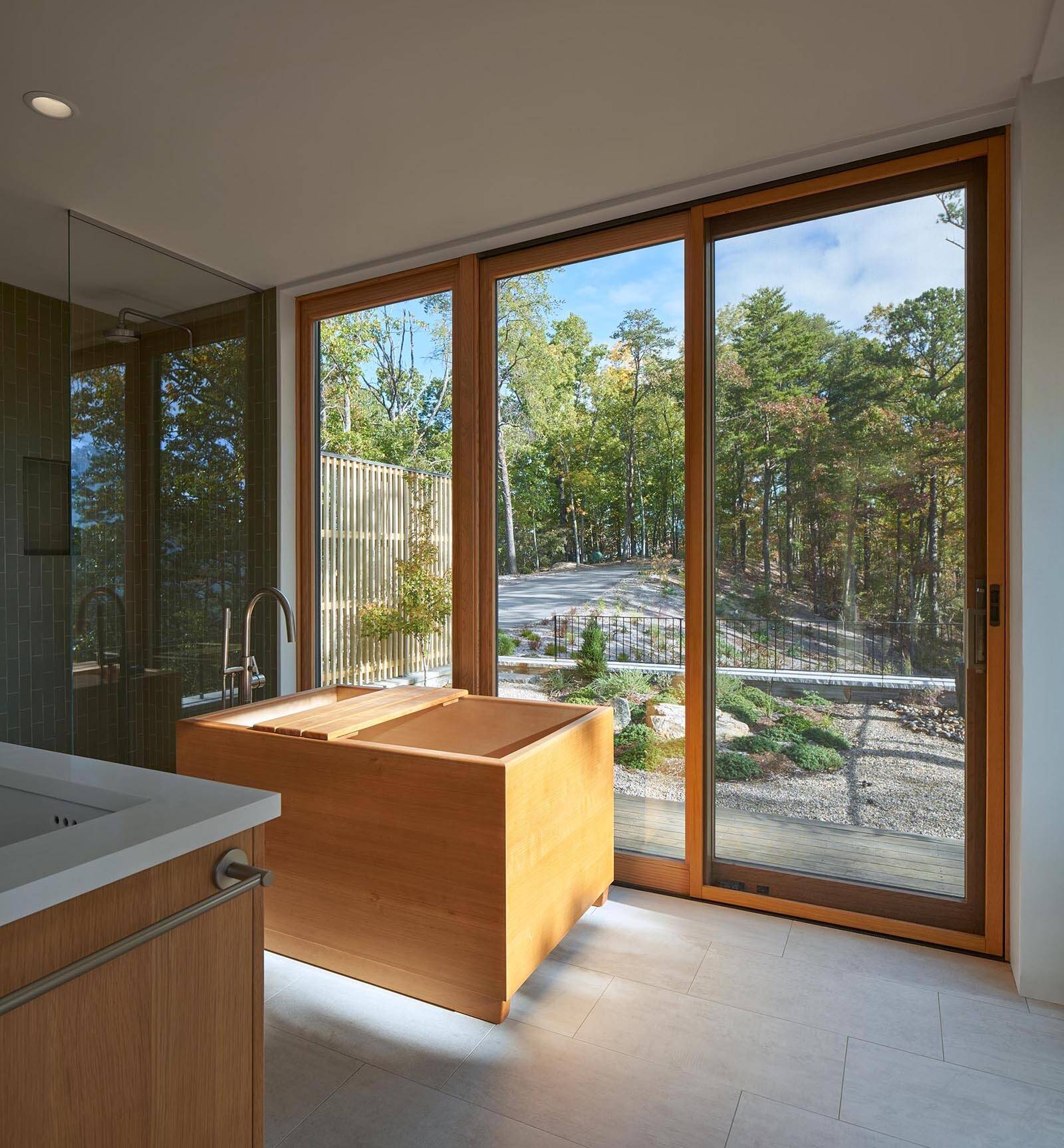 A deep wood soaking tub brings a calm, spa-like feel with subtle Japanese design influence.
