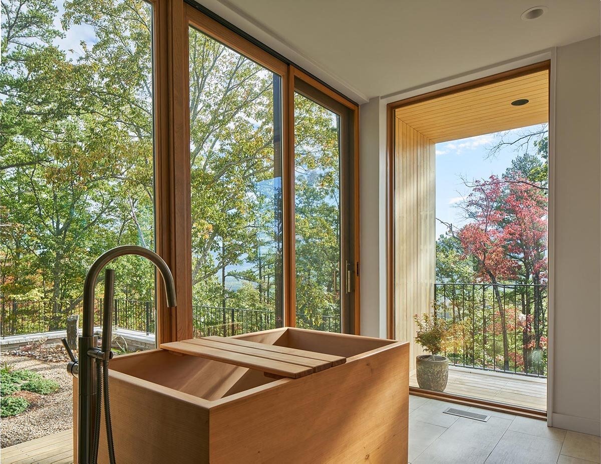 A deep wood soaking tub brings a calm, spa-like feel with subtle Japanese design influence.