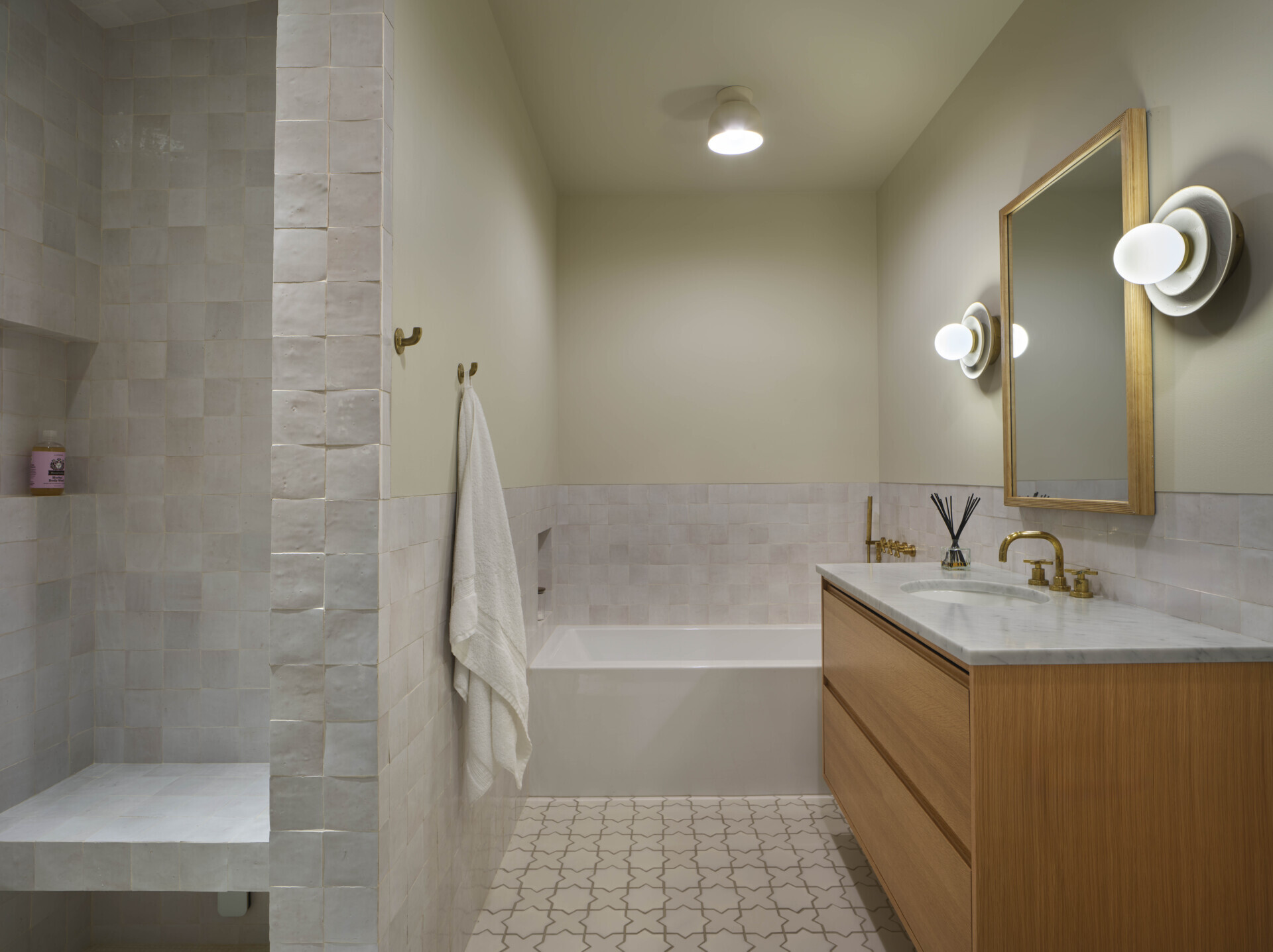This bathroom has a built-in tub that blends into the overall layout, while the square tiles add a textural element.