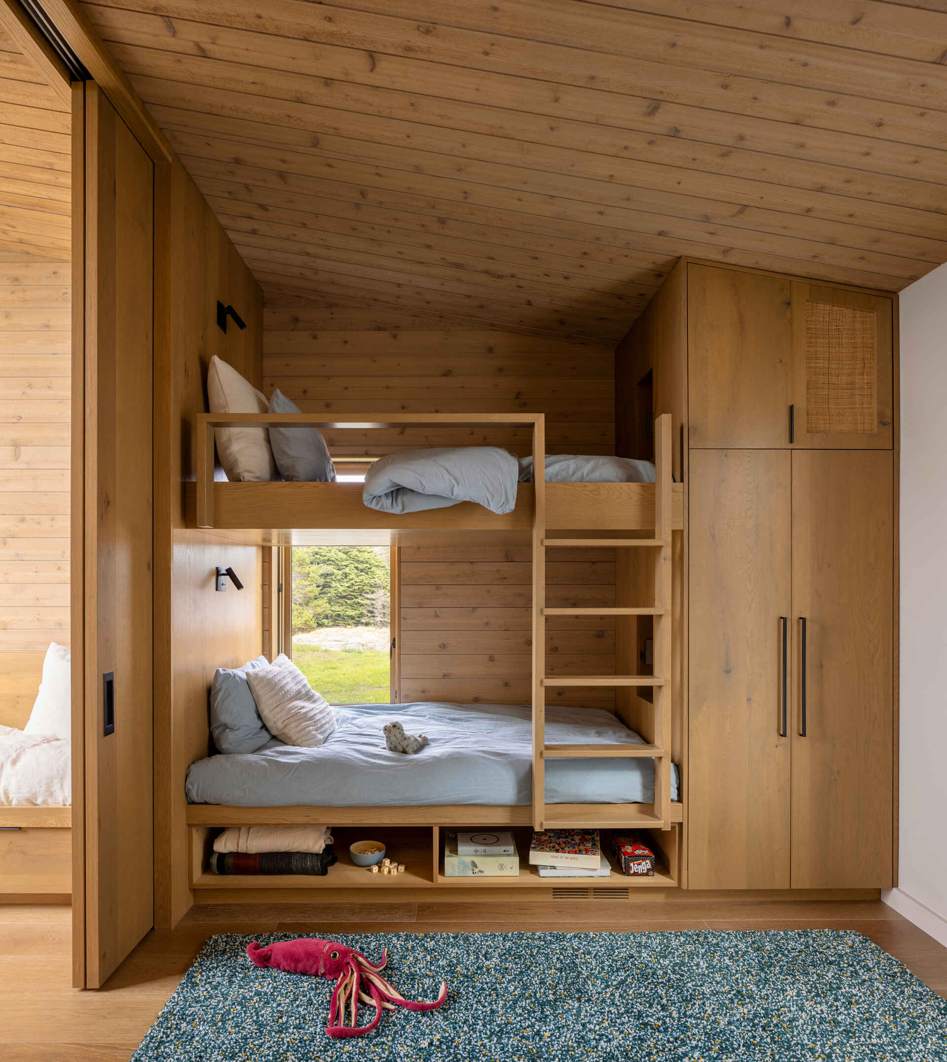 A loft suite includes built-in bunk beds and storage. This space looks out over the top of the rock formation, offering a completely different perspective of the site. It’s designed with flexibility in mind, perfect for hosting family or friends.