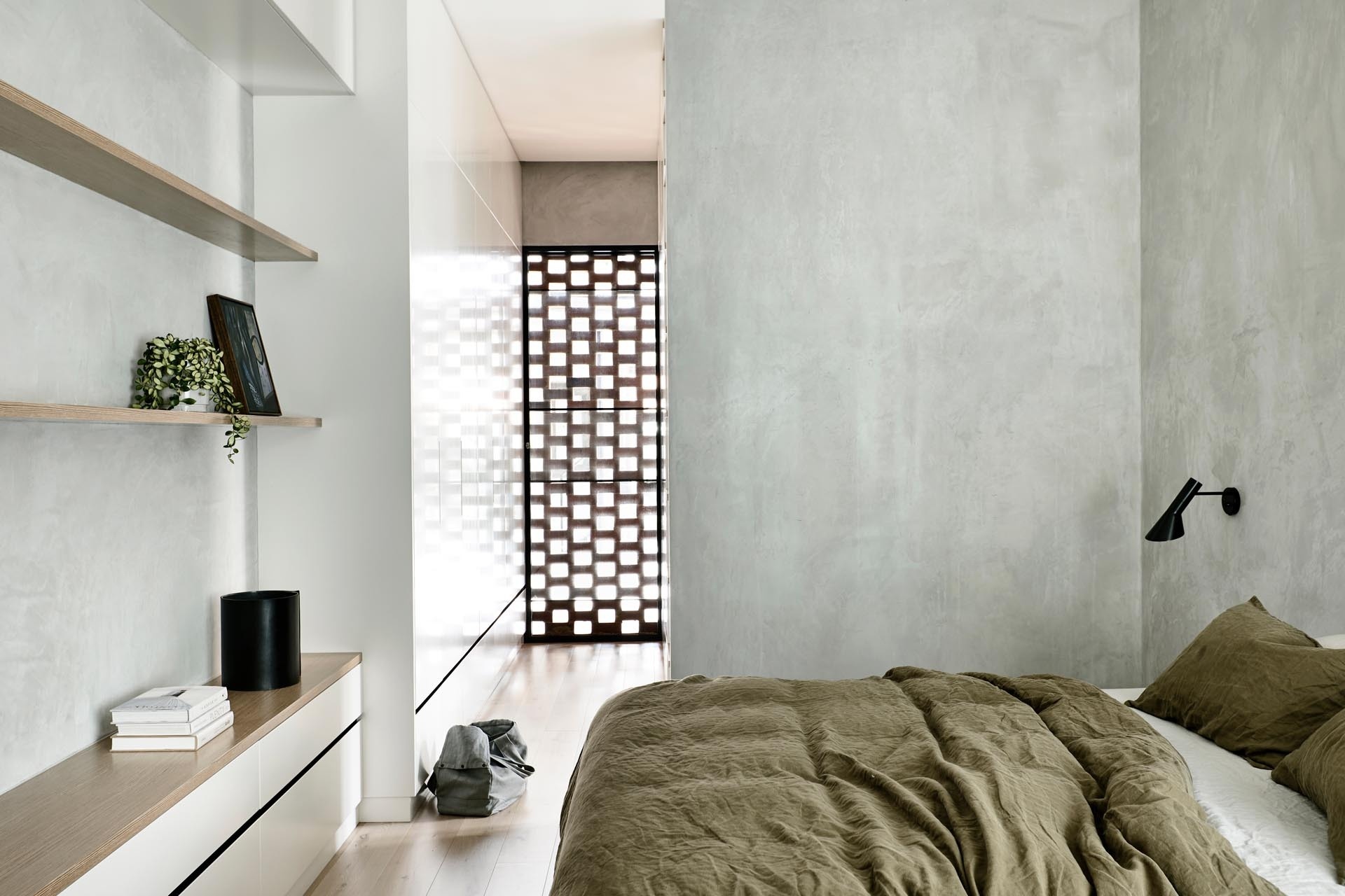 A modern bedroom uses hit-miss brickwork to filter light, creating soft patterns that add depth without adding clutter.