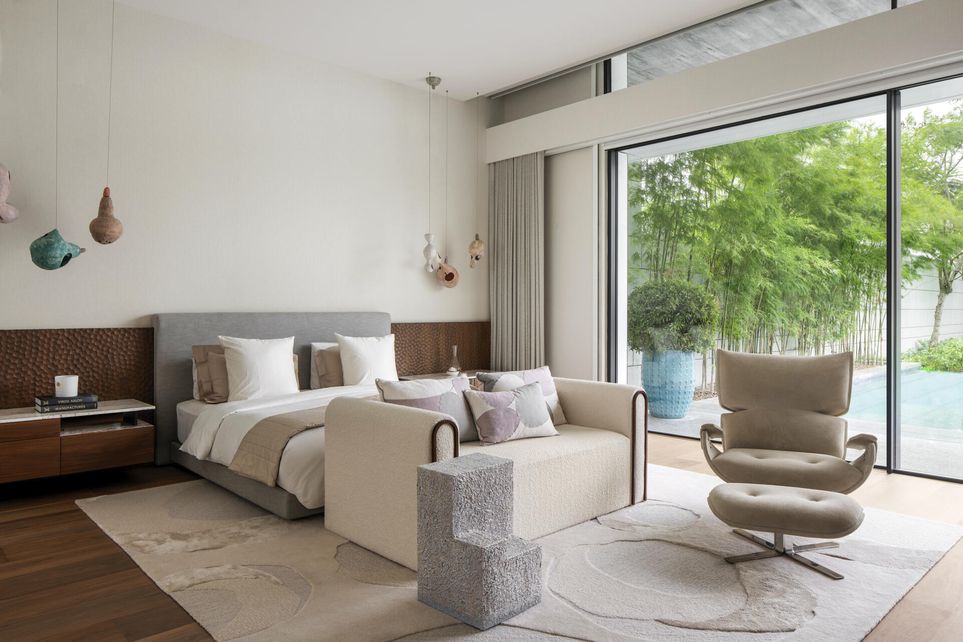 In the main bedroom, the tone shifts. The palette becomes more muted, and the forms are simplified. The focus moves toward comfort, with softer textures and a more restrained use of color. Even so, the sculptural influence remains, visible in the choice of furniture and lighting.