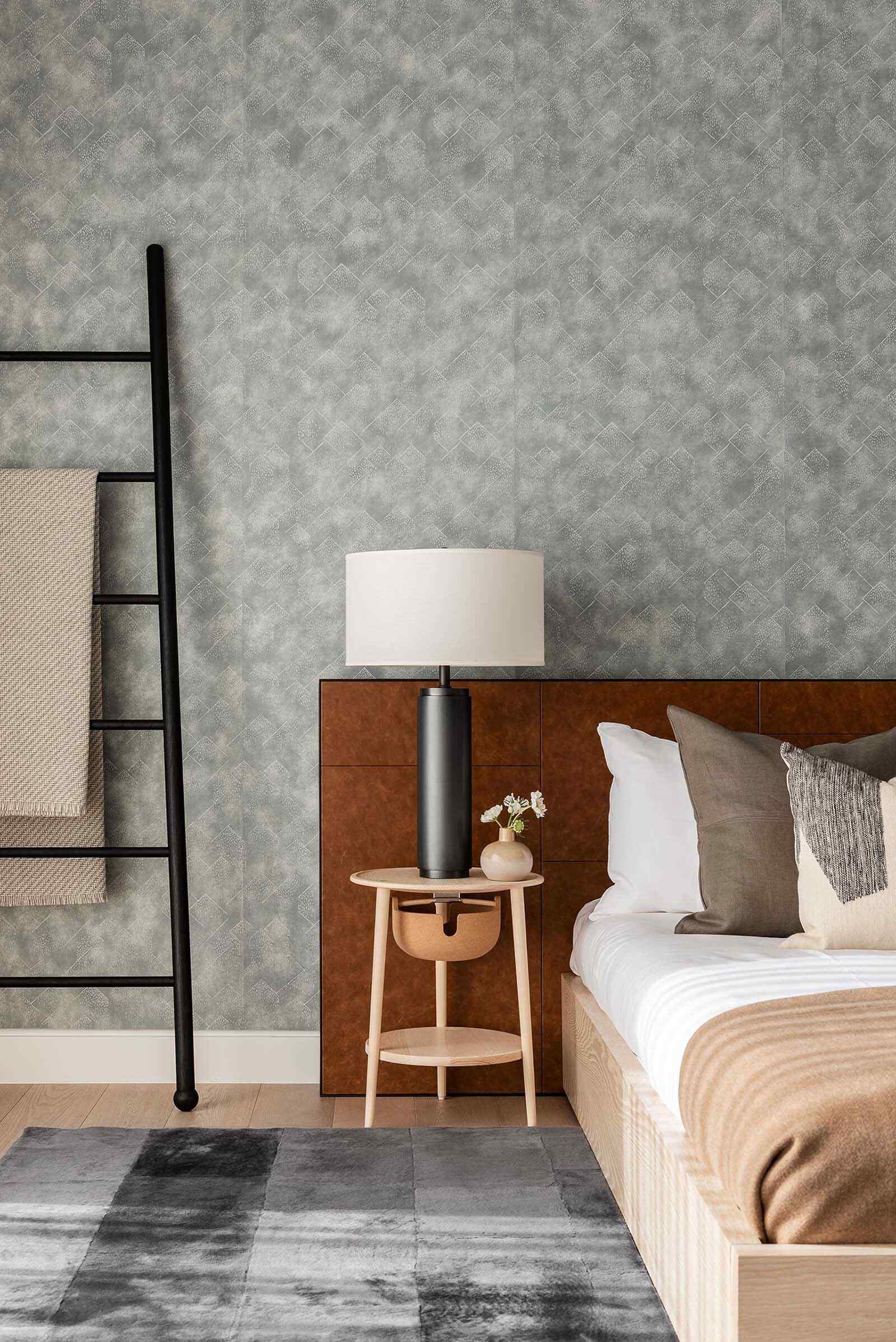 Minimal bedroom with gray wallpaper, pendant lighting, and a matte black ladder for a clean modern look.