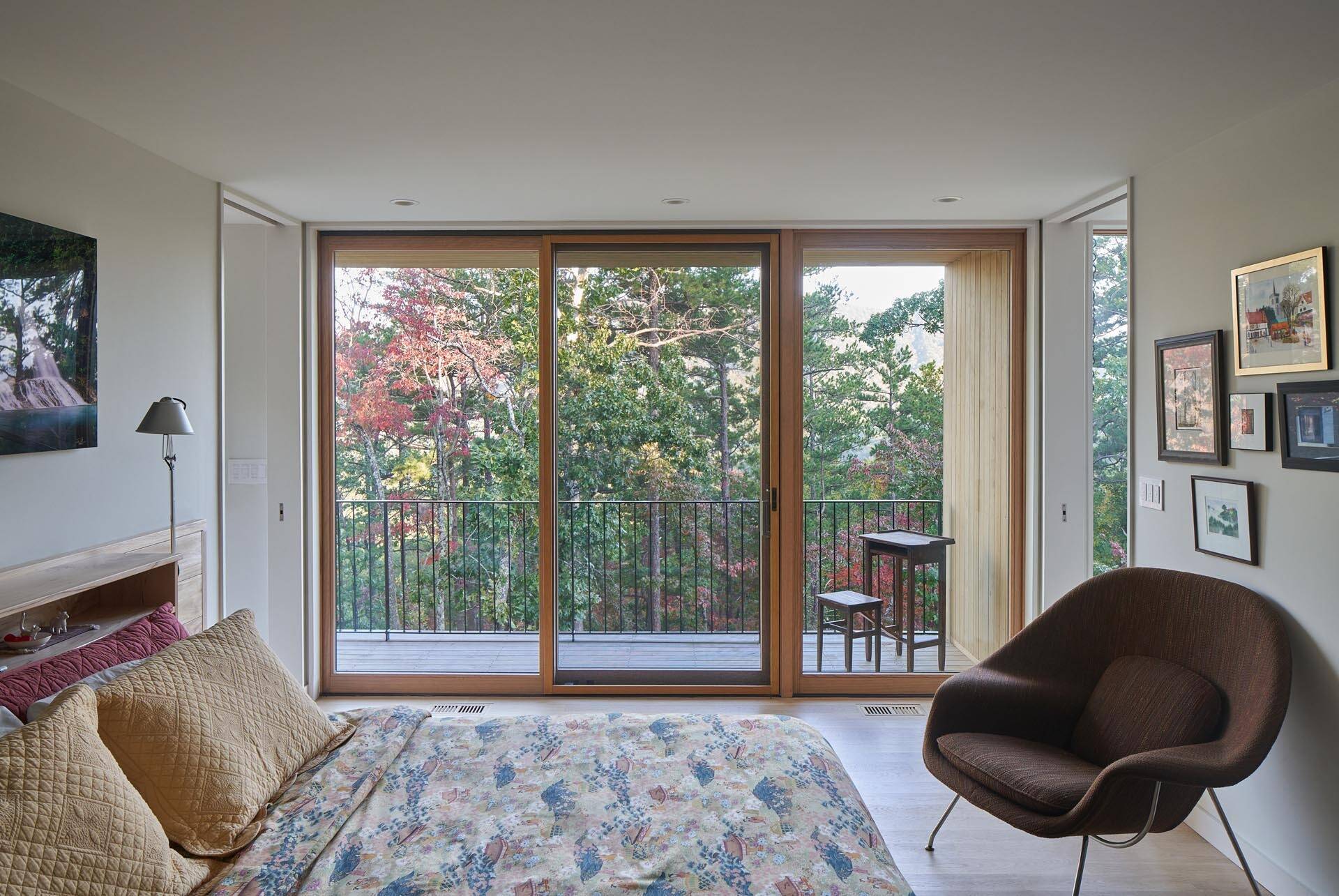 A sliding glass door opens the bedroom to a private outdoor space tucked into the landscape.