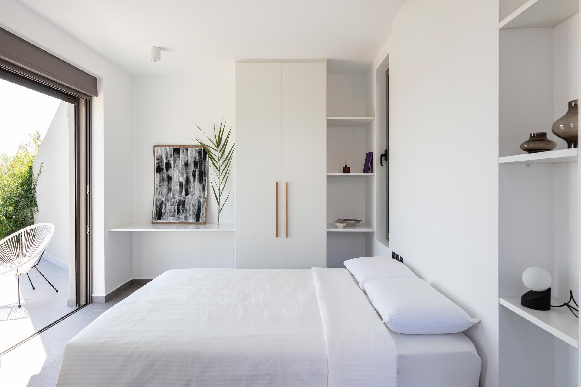 Bright, minimalist interiors with high ceilings and all-white bedrooms reflect the calm, airy feel of these modern Greek villas.