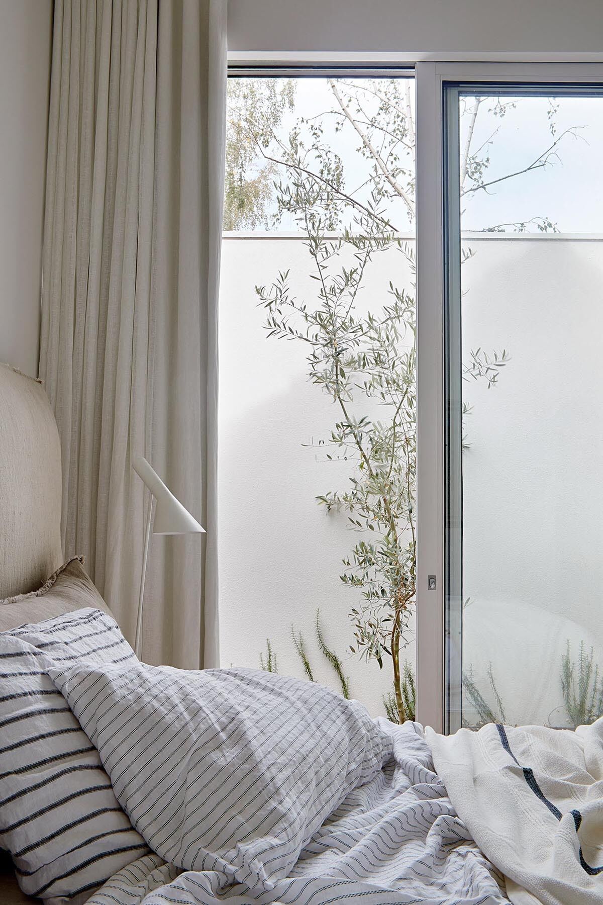 A serene bedroom with direct garden access, offering a private outdoor escape just steps from the bed.