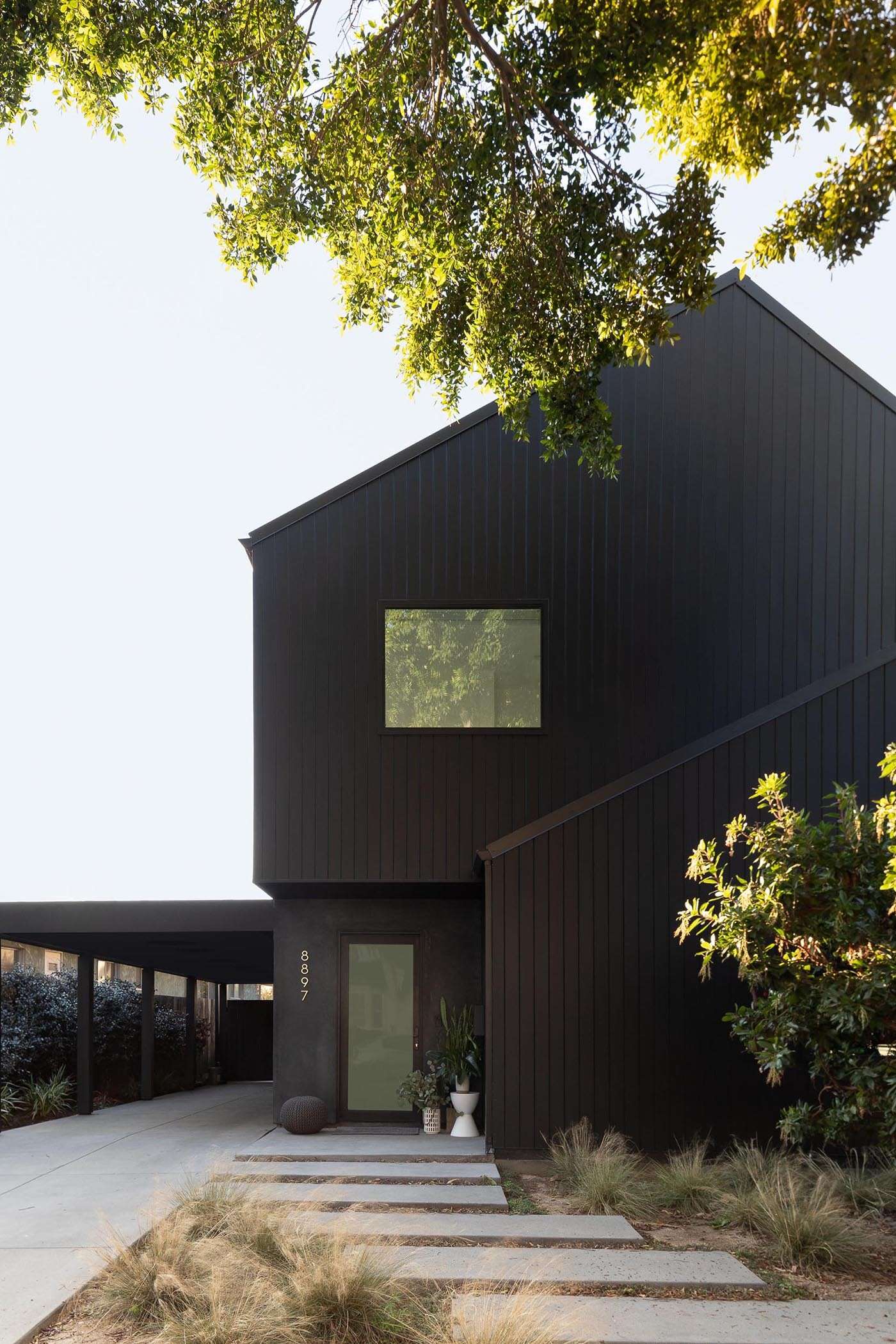 A modern black gabled home in Hermosa Beach with a sculptural exterior inspired by barn forms and Japanese design techniques.