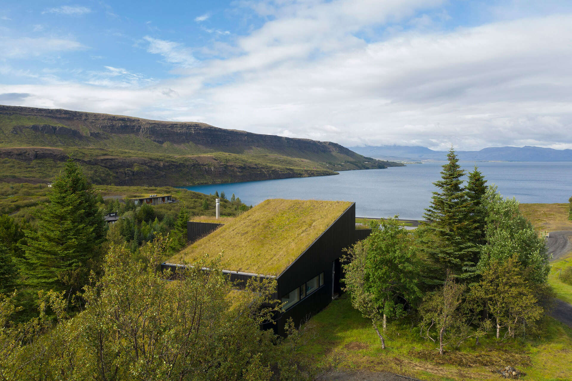 This Icelandic holiday home features a green roof covered in moss and grass, accessible from inside with views over Þingvallavatn.