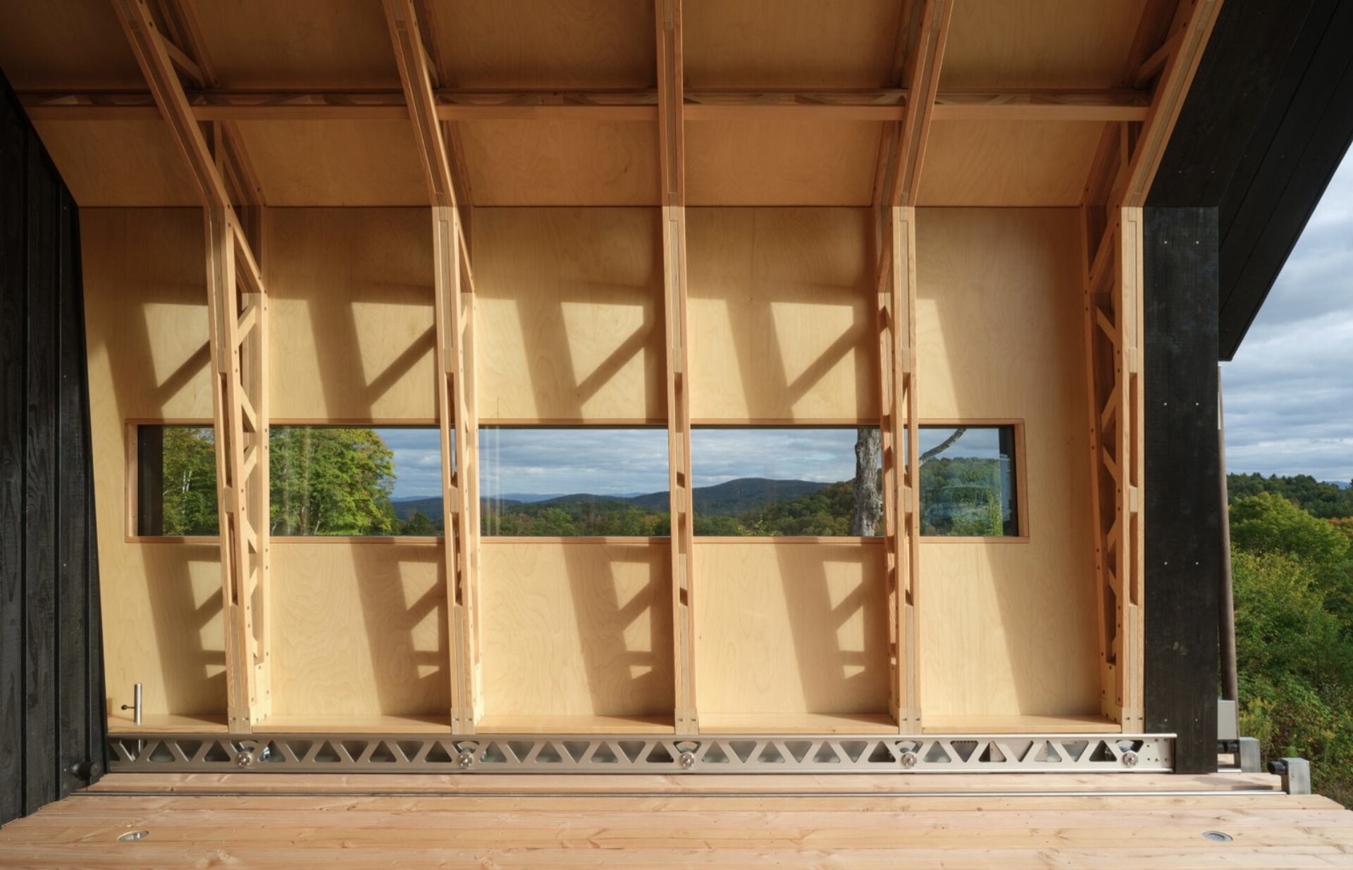 A small cabin in Vermont that physically transforms throughout the day. Cabin ANNA uses sliding timber and glass shells to create a space that can fully open to the outdoors in seconds.