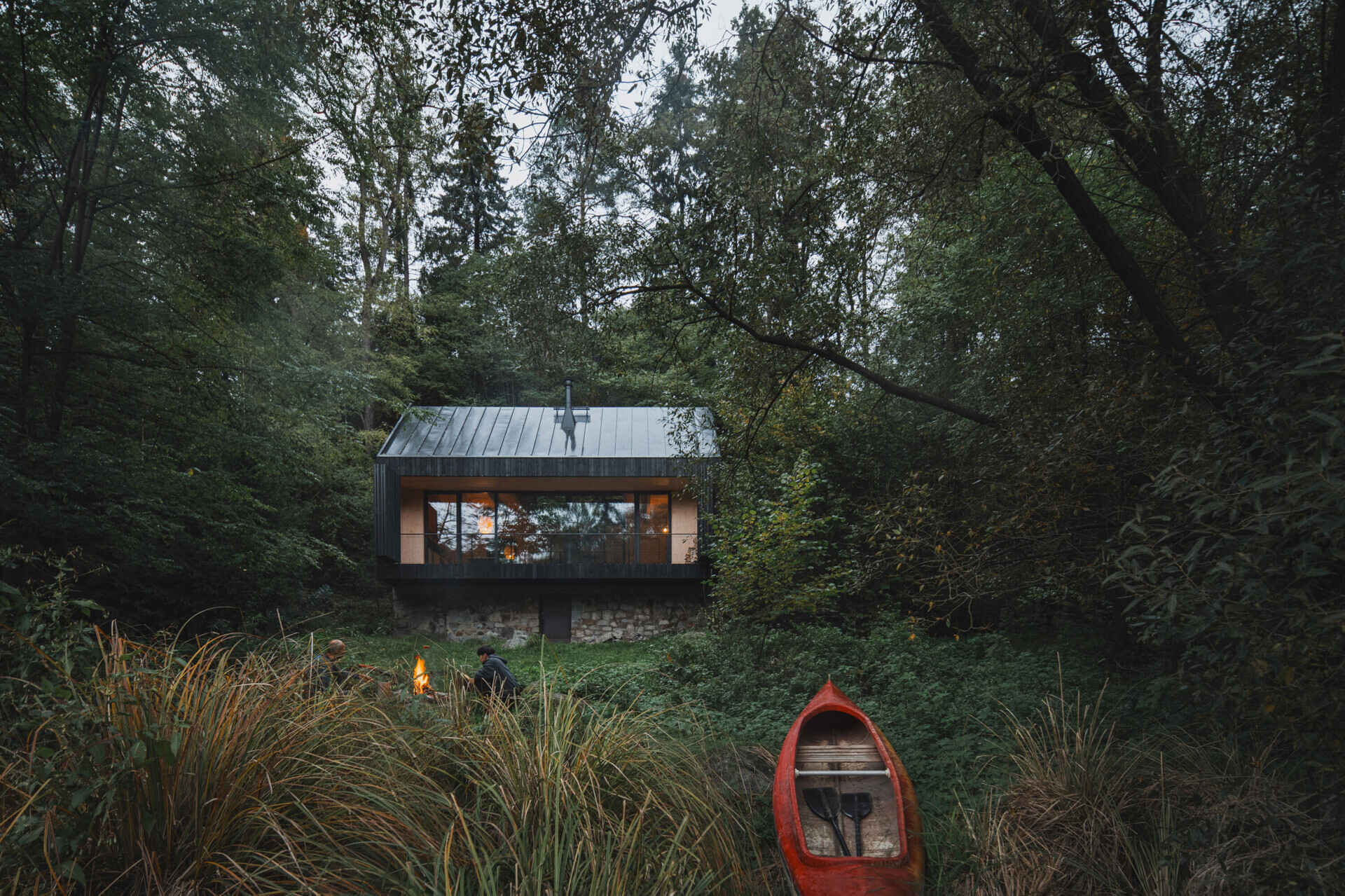 Charred larch cladding and folding shutters give this cabin a bold exterior that can fully open to the river or close into a secure box.
