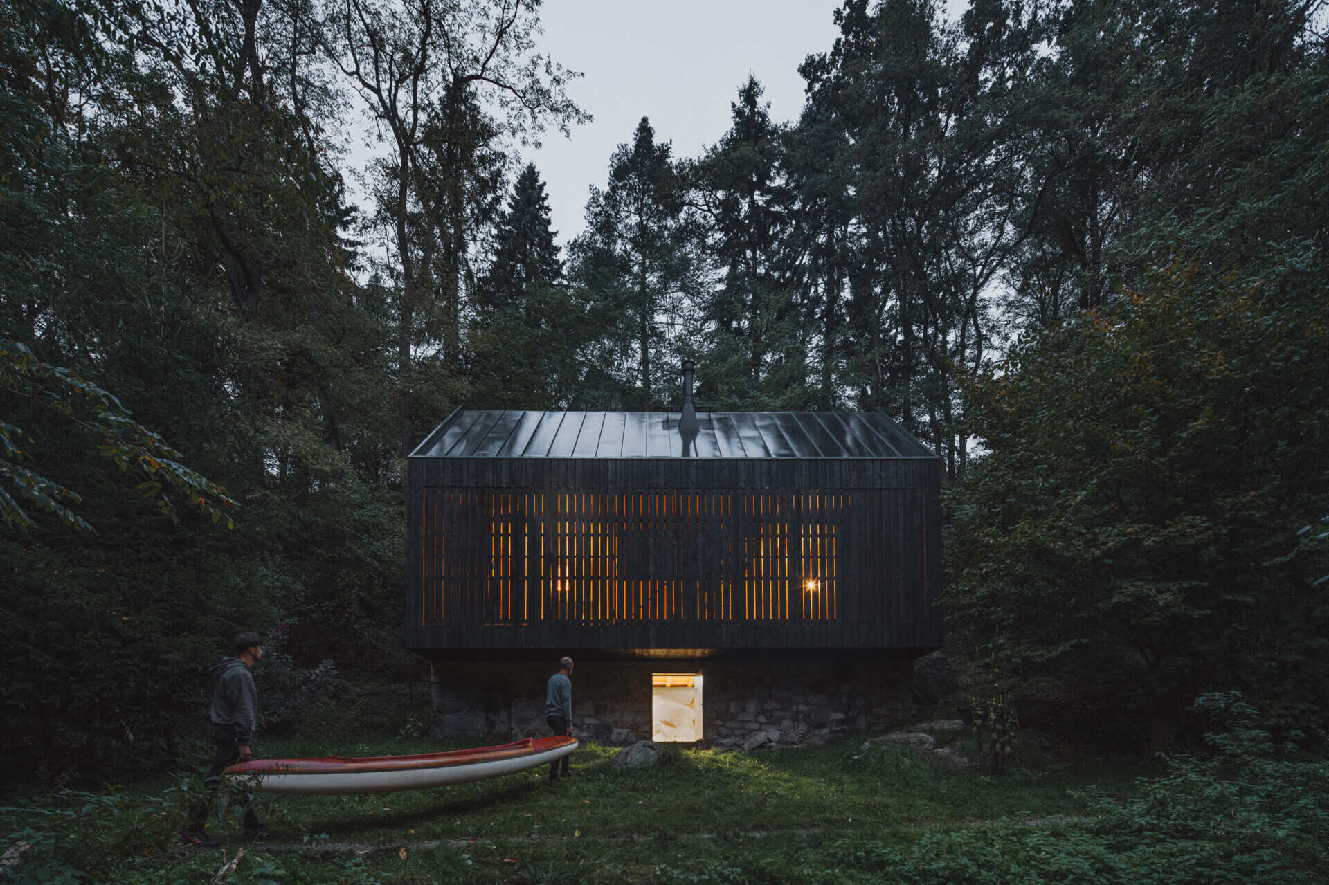 Charred larch cladding and folding shutters give this cabin a bold exterior that can fully open to the river or close into a secure box.