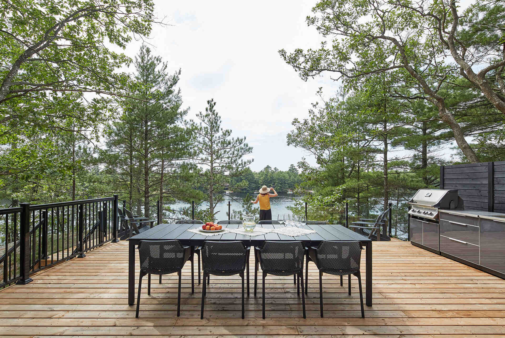 Two outdoor dining areas, including a lake-facing deck and covered space, create flexible entertaining zones for this Muskoka cottage.