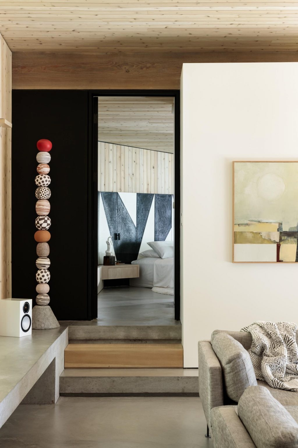 A bright bedroom with a full wall of windows and a bold black and white accent wall that adds a modern edge.