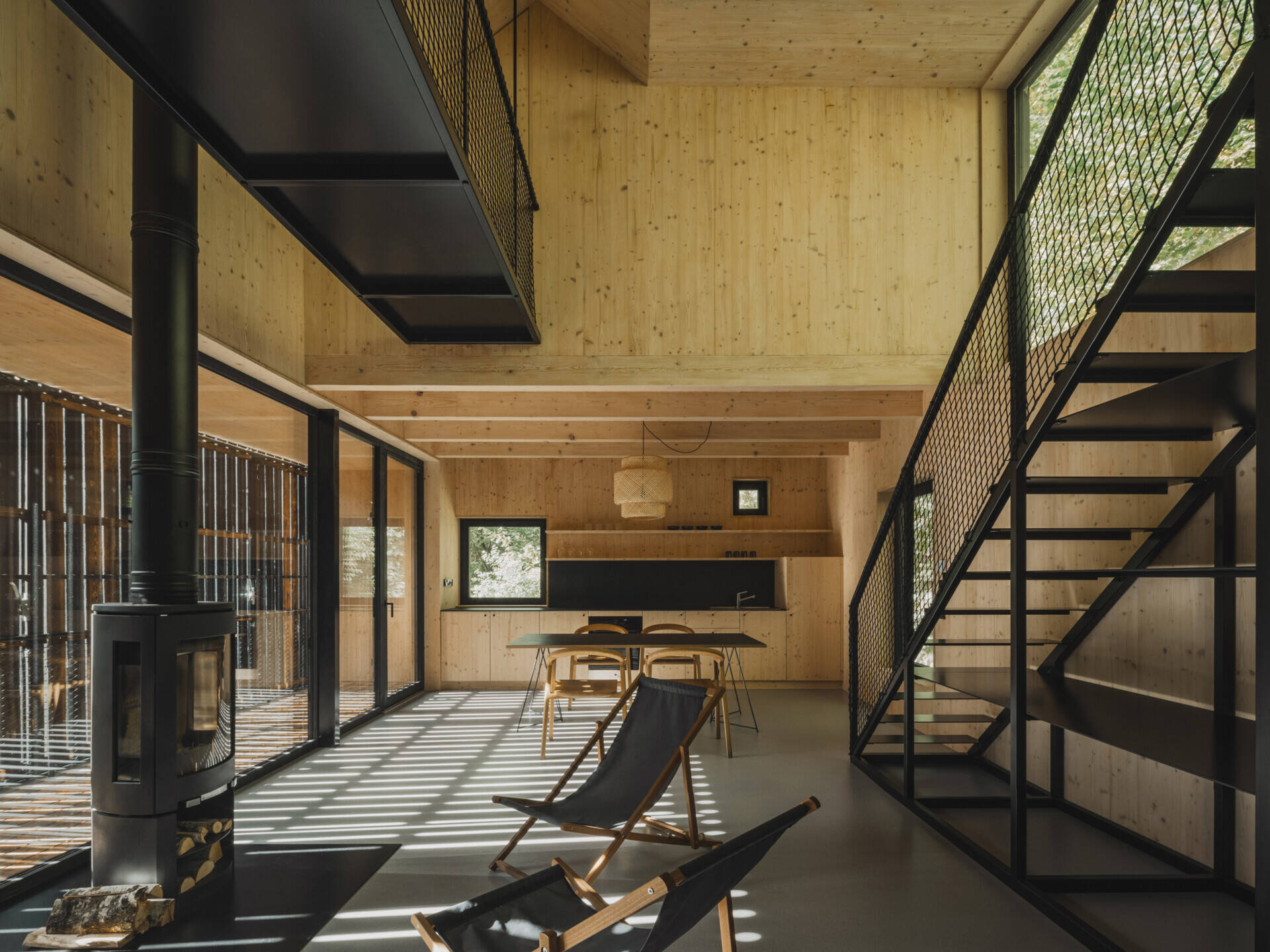 In this cabin, a full-height living space with floor-to-ceiling glazing connects seamlessly to a raised terrace overlooking the river.