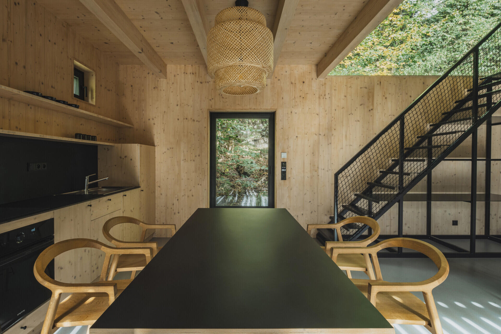 In this cabin, a full-height living space with floor-to-ceiling glazing connects seamlessly to a raised terrace overlooking the river.