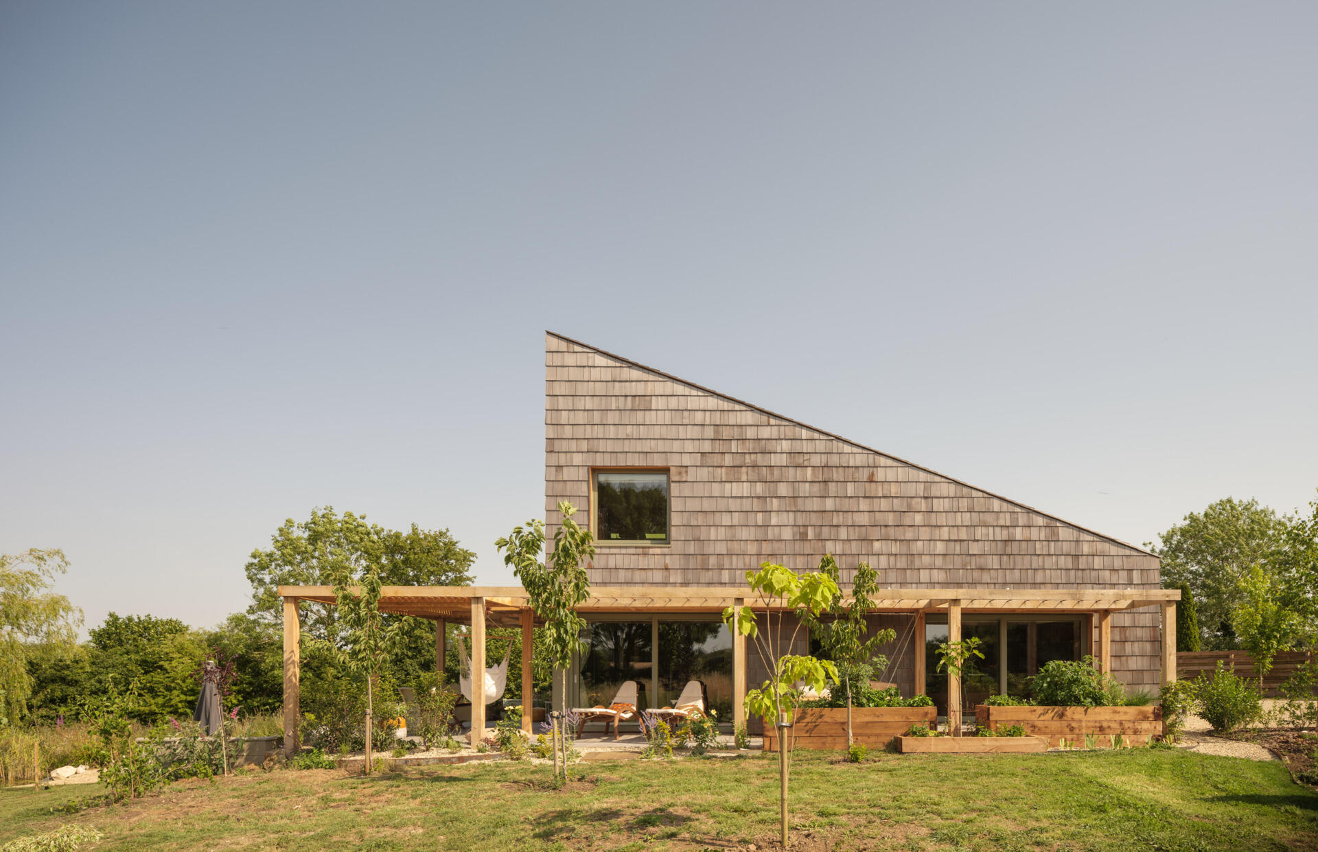Western red cedar shingles wrap this wedge house, creating a warm exterior that will age beautifully over time.