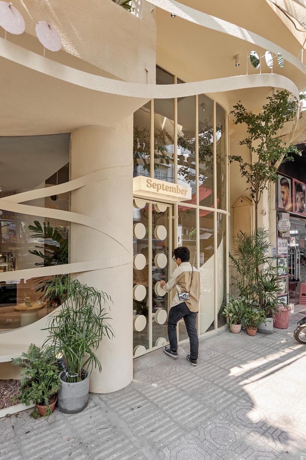 A curved outdoor seating area and circular entry details create an inviting transition from street to café.