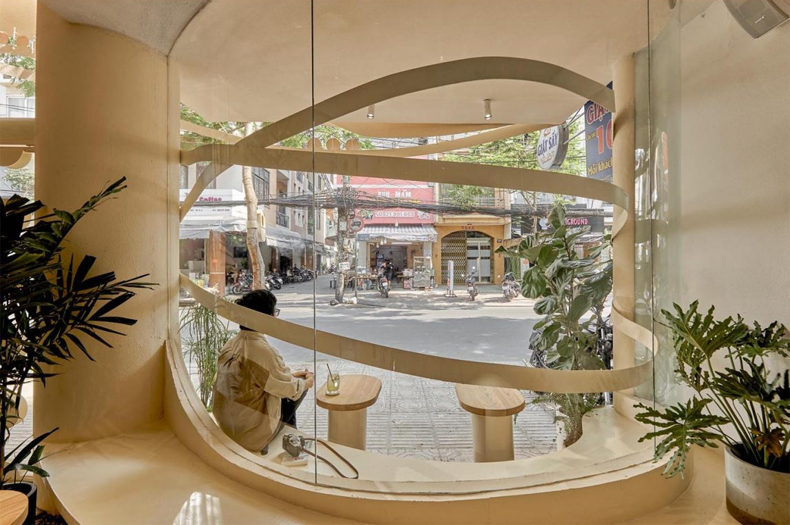 Neutral tones, natural wood, and layered greenery create a calm and welcoming café interior.