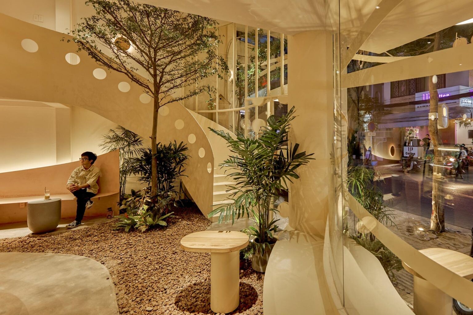 An indoor café space designed to feel open and airy, with greenery and bar seating that invites interaction.