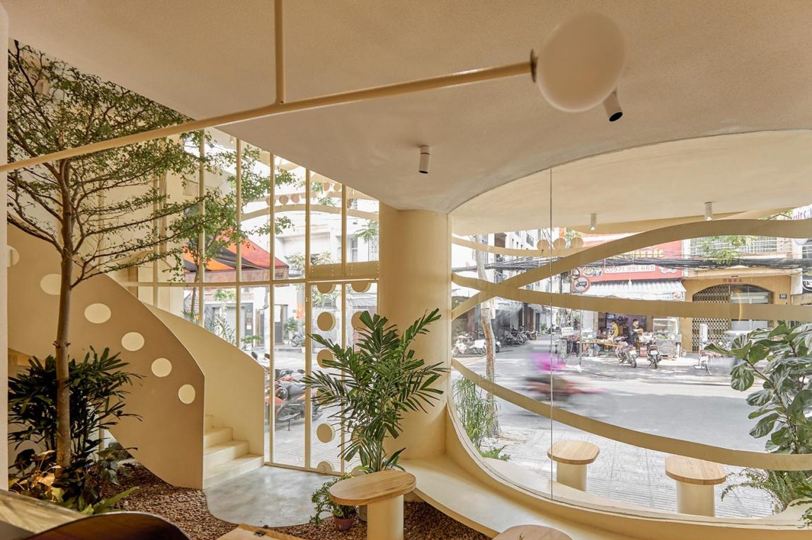 Neutral tones, natural wood, and layered greenery create a calm and welcoming café interior.