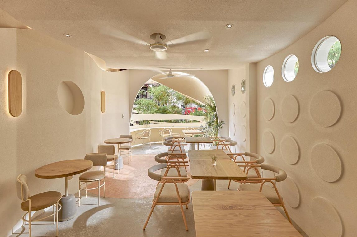 An open-air café level with circular design details and neighborhood views adds a unique outdoor experience.