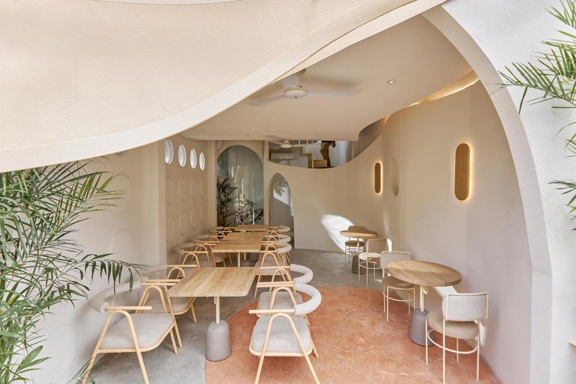 An open-air café level with circular design details and neighborhood views adds a unique outdoor experience.