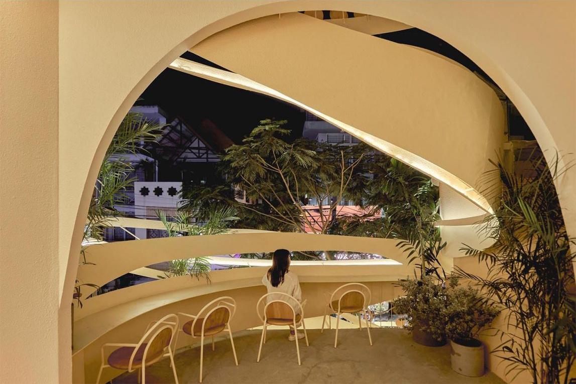 An open-air café level with circular design details and neighborhood views adds a unique outdoor experience.
