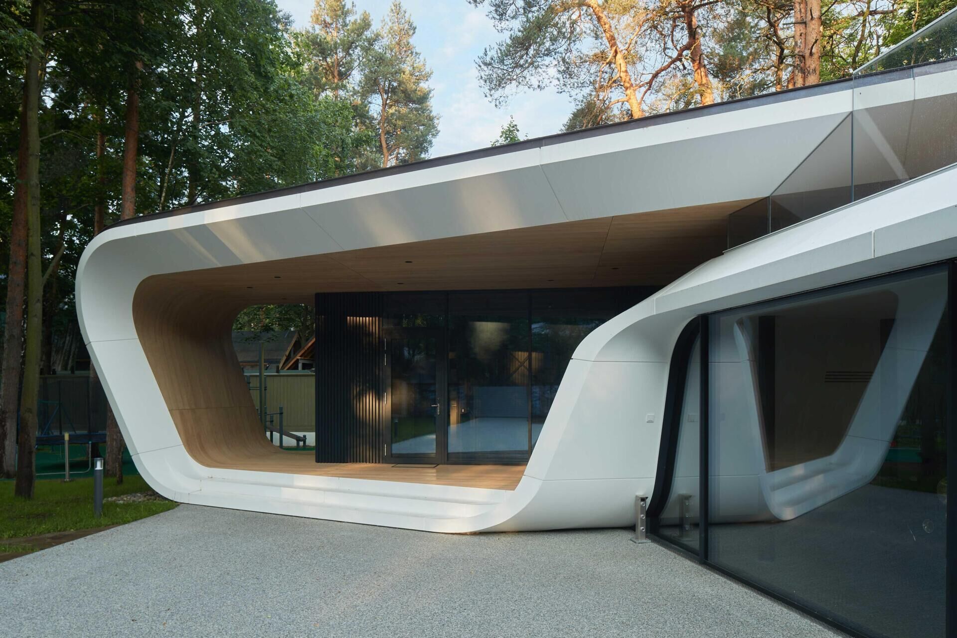 A modern garage by ATRIUM expands a private estate, turning car storage into a striking architectural feature in a forest setting.