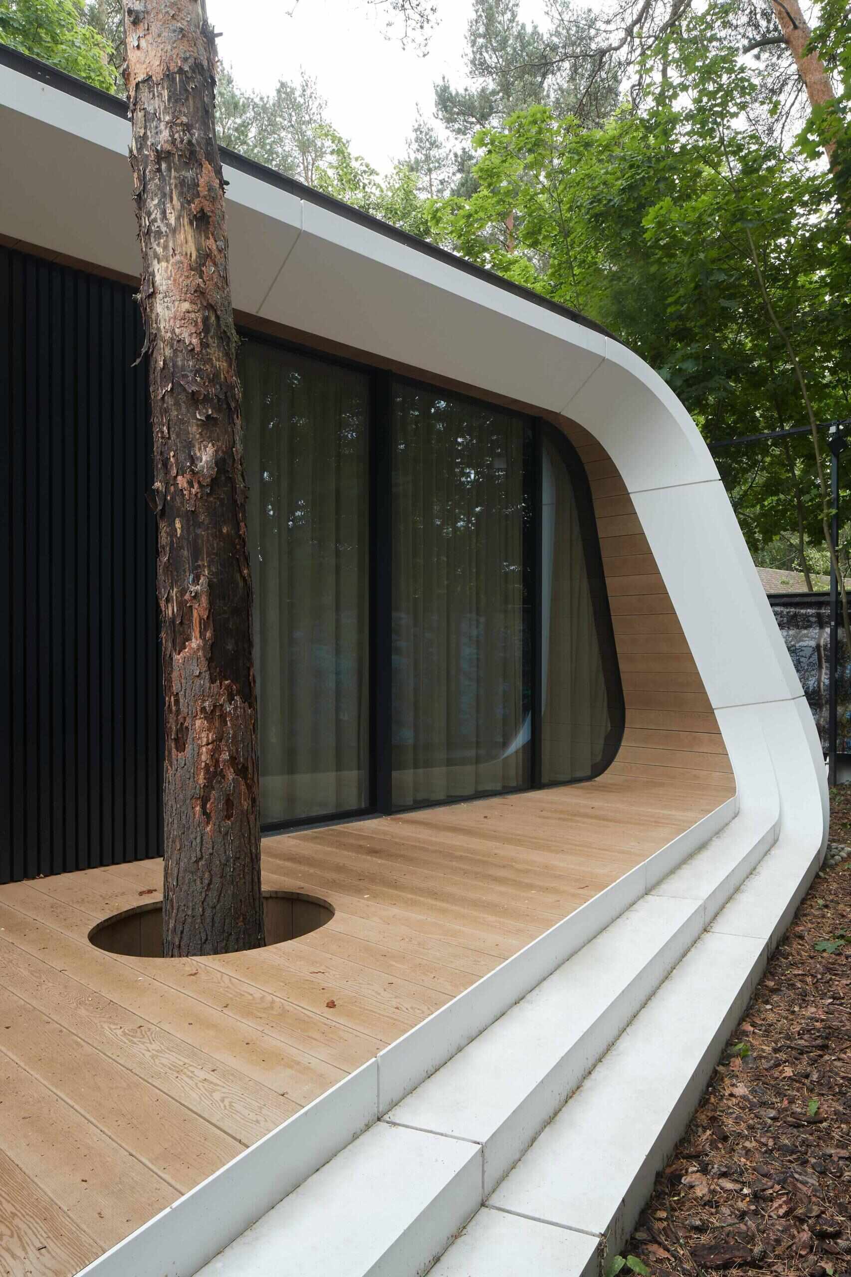 A modern garage by ATRIUM expands a private estate, turning car storage into a striking architectural feature in a forest setting.