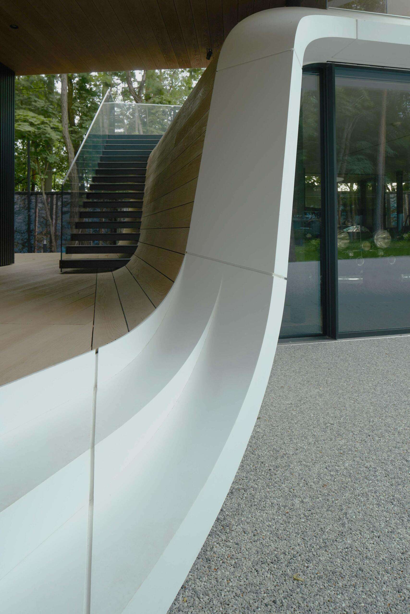 A modern garage by ATRIUM expands a private estate, turning car storage into a striking architectural feature in a forest setting.