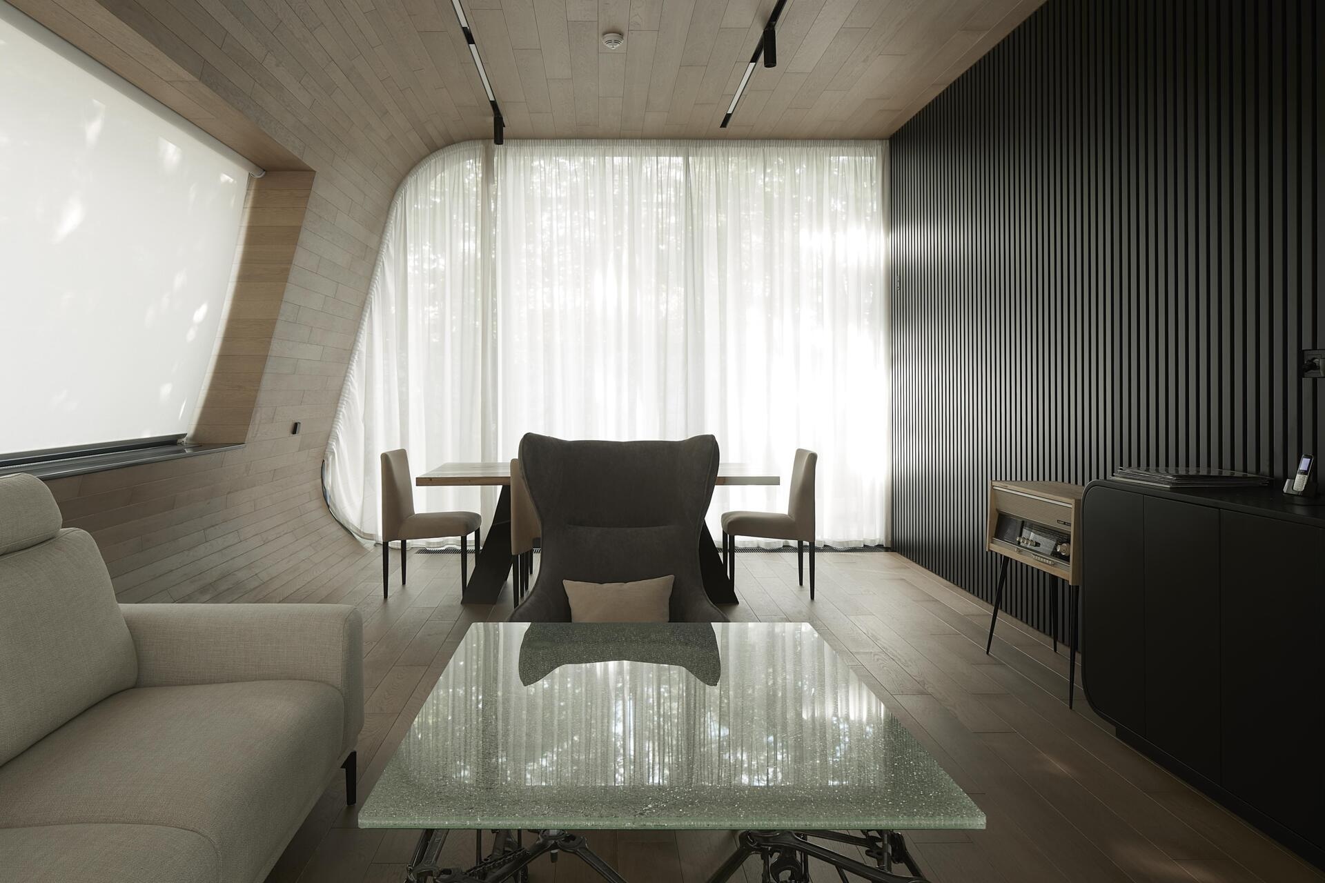 A modern garage by ATRIUM expands a private estate, turning car storage into a striking architectural feature in a forest setting.