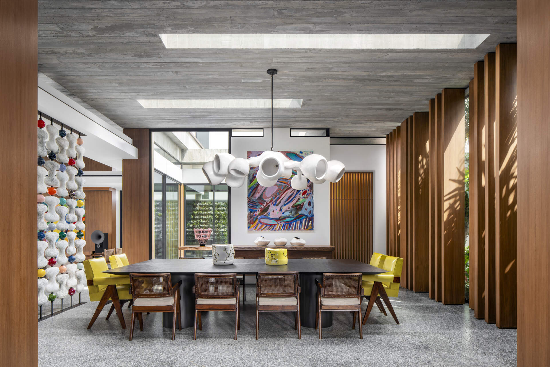 A sculptural divider separates living and dining areas while retro-inspired details add contrast.