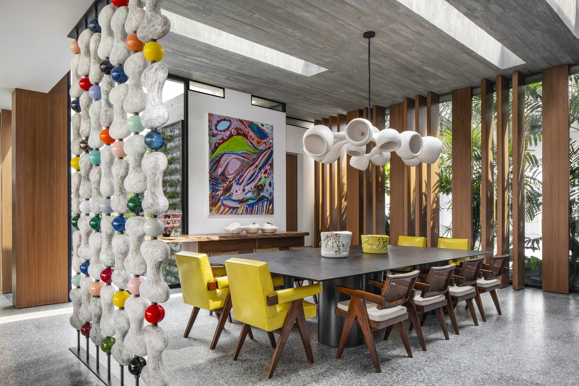 A sculptural divider separates living and dining areas while retro-inspired details add contrast.