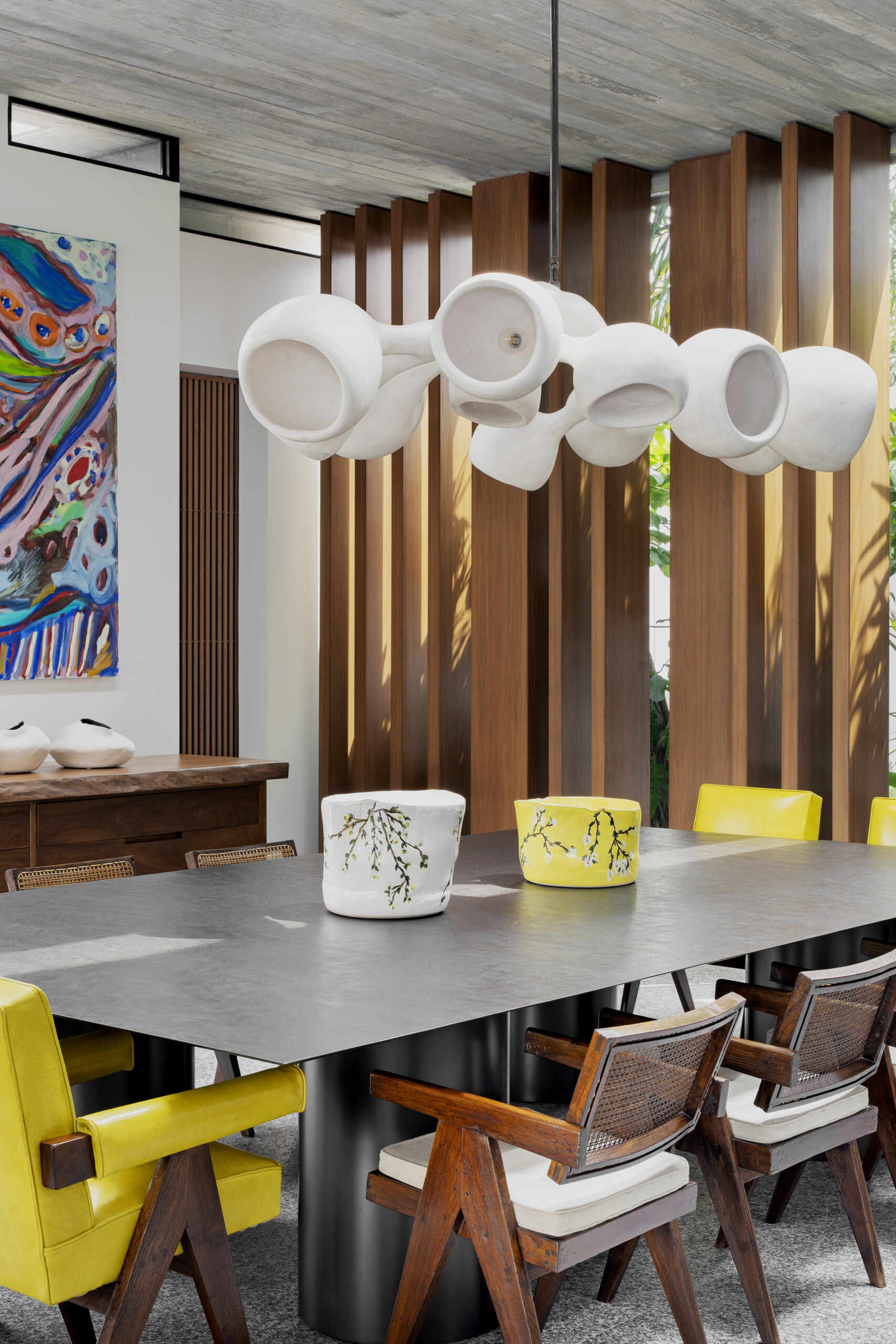 A sculptural divider separates living and dining areas while retro-inspired details add contrast.