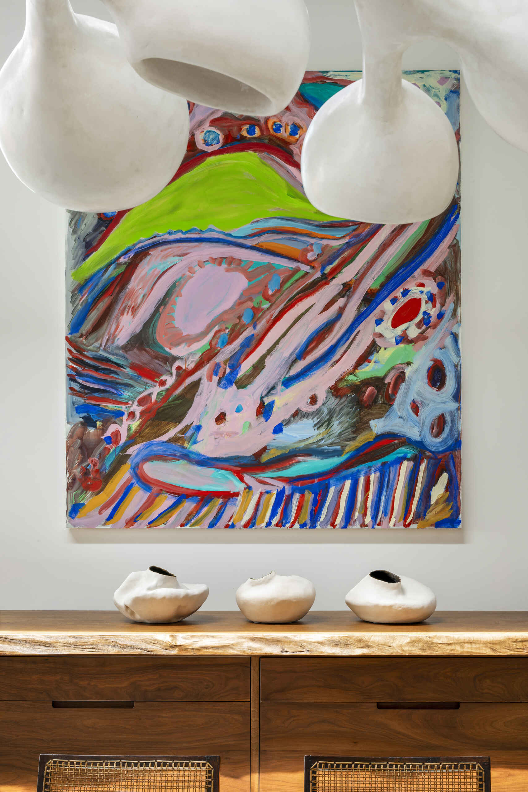 A sculptural divider separates living and dining areas while retro-inspired details add contrast.