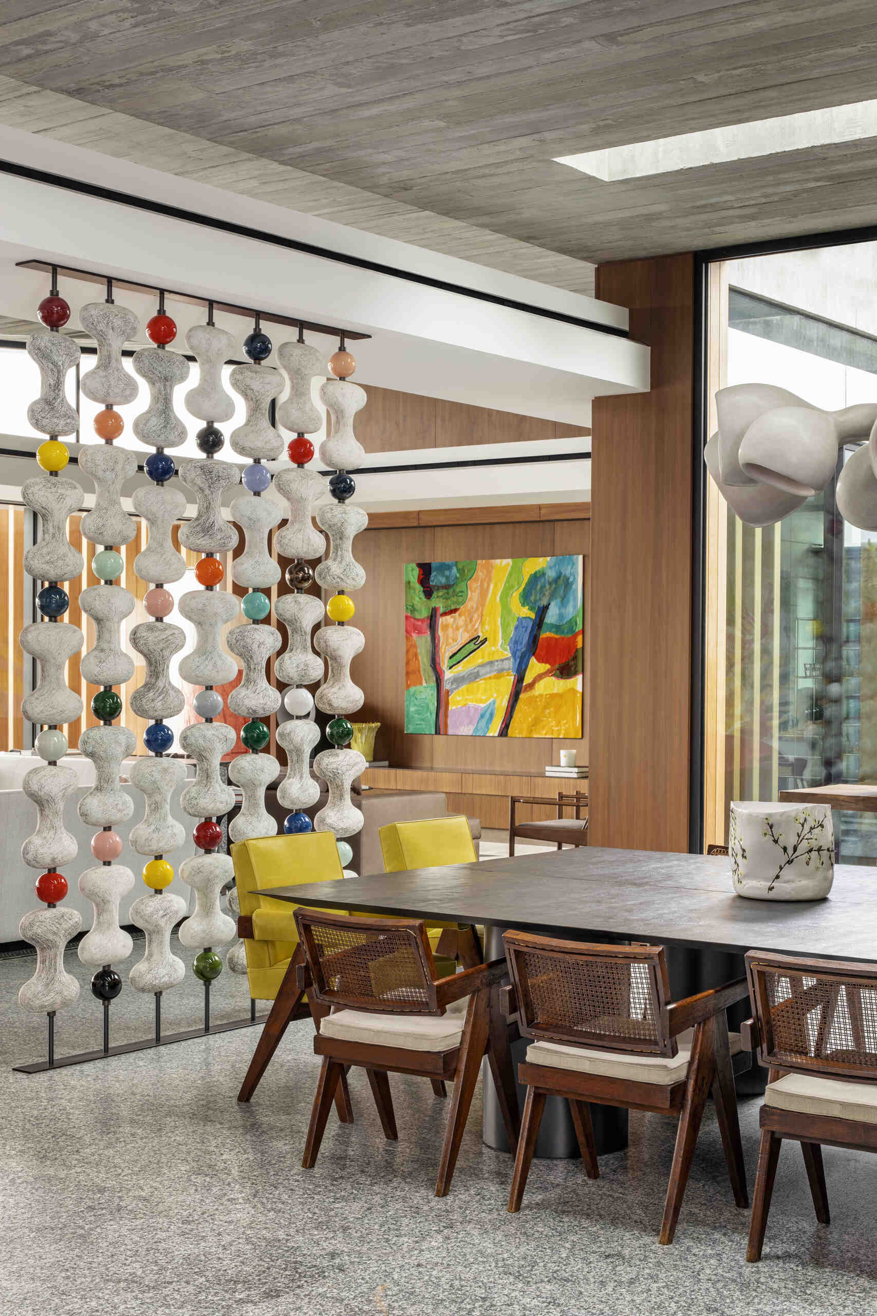 A sculptural divider separates living and dining areas while retro-inspired details add contrast.