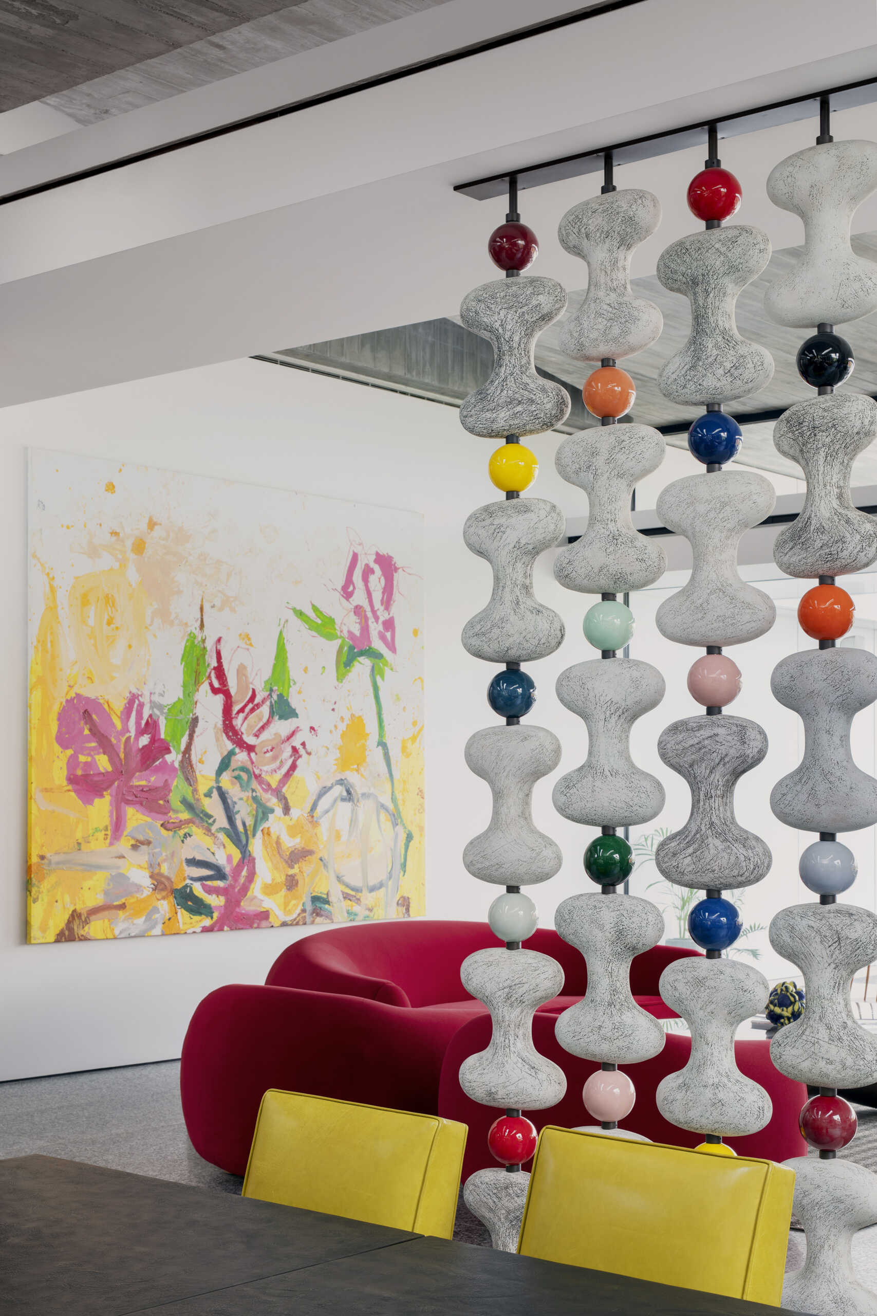 A sculptural divider separates living and dining areas while retro-inspired details add contrast.