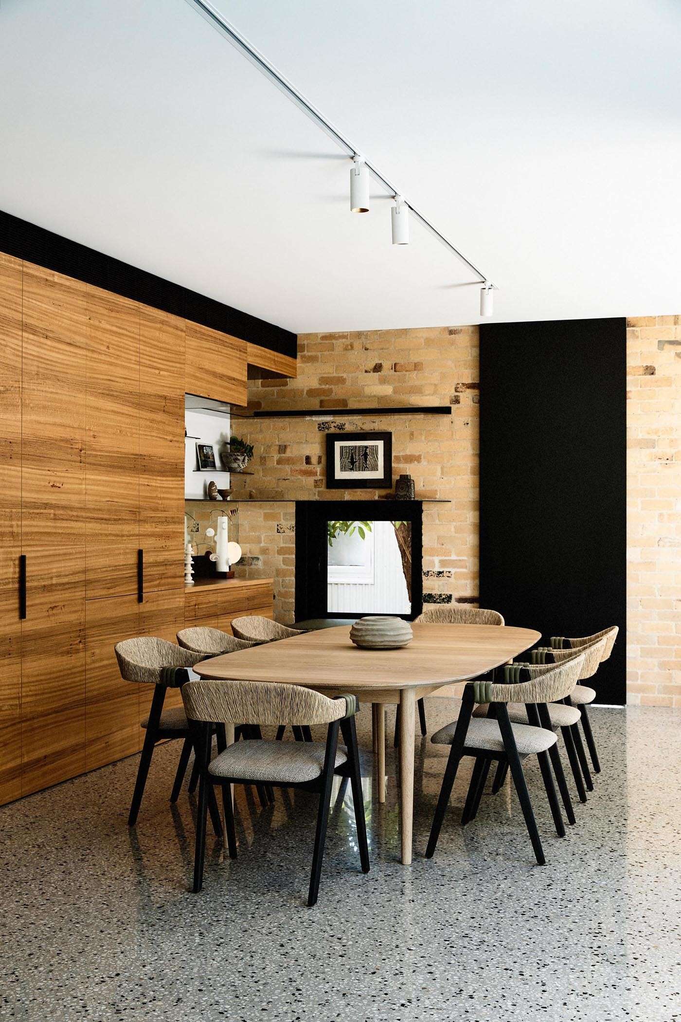 Wood cabinetry flows from the kitchen into the dining area, forming a built-in niche with shelving. 
