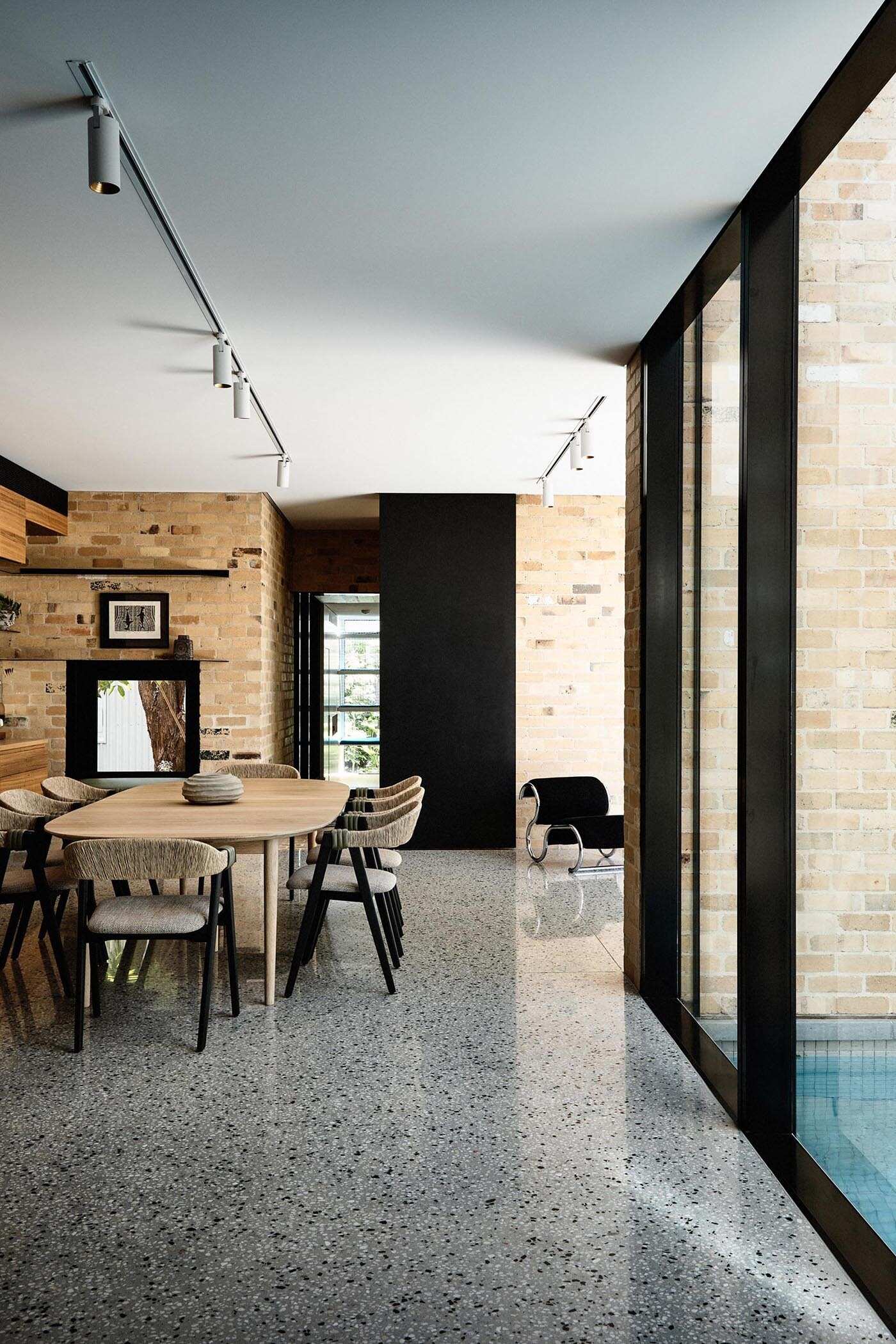 Wood cabinetry flows from the kitchen into the dining area, forming a built-in niche with shelving. 