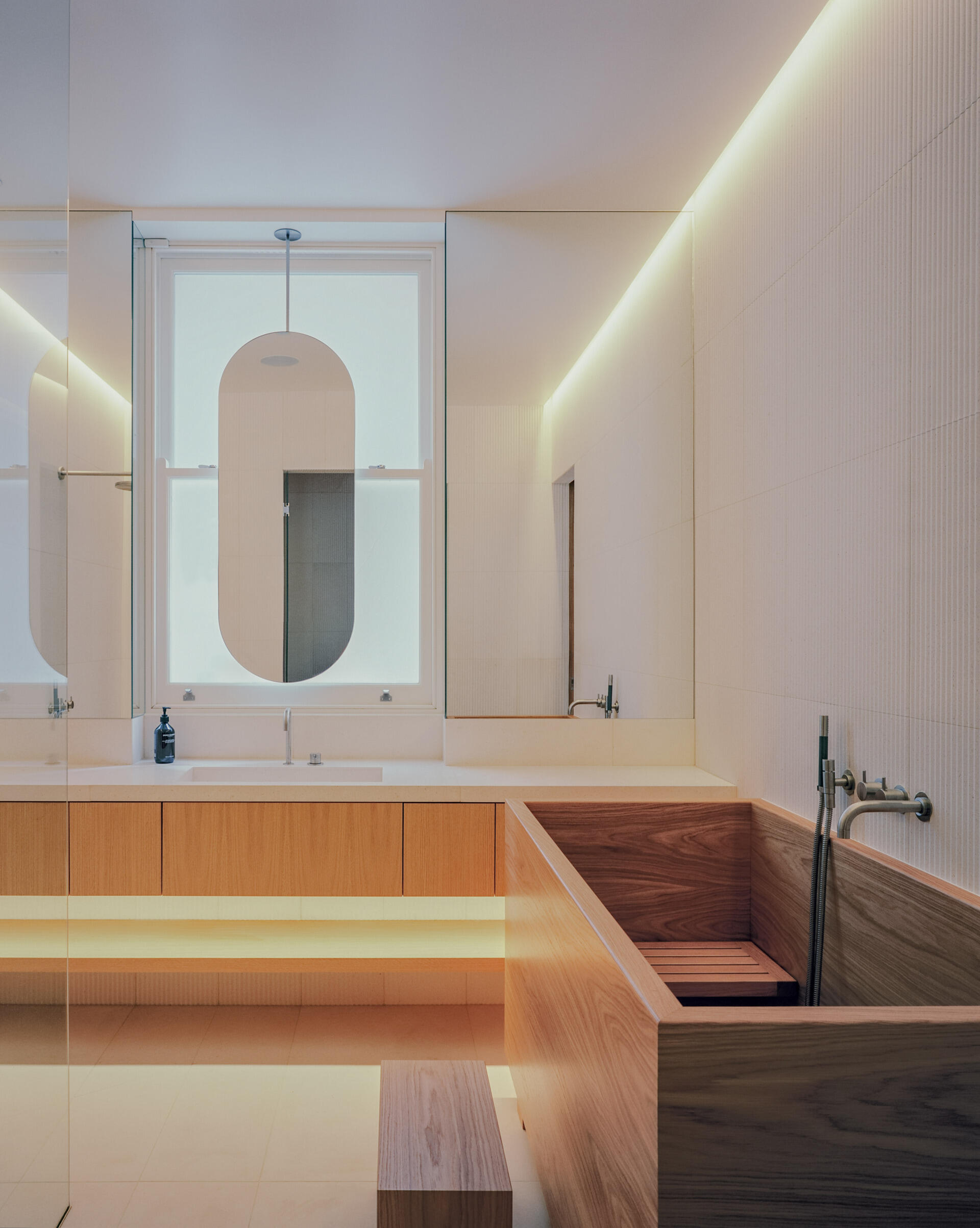 A private bedroom suite with an integrated office and a deep wood soaking tub blends function with standout design.