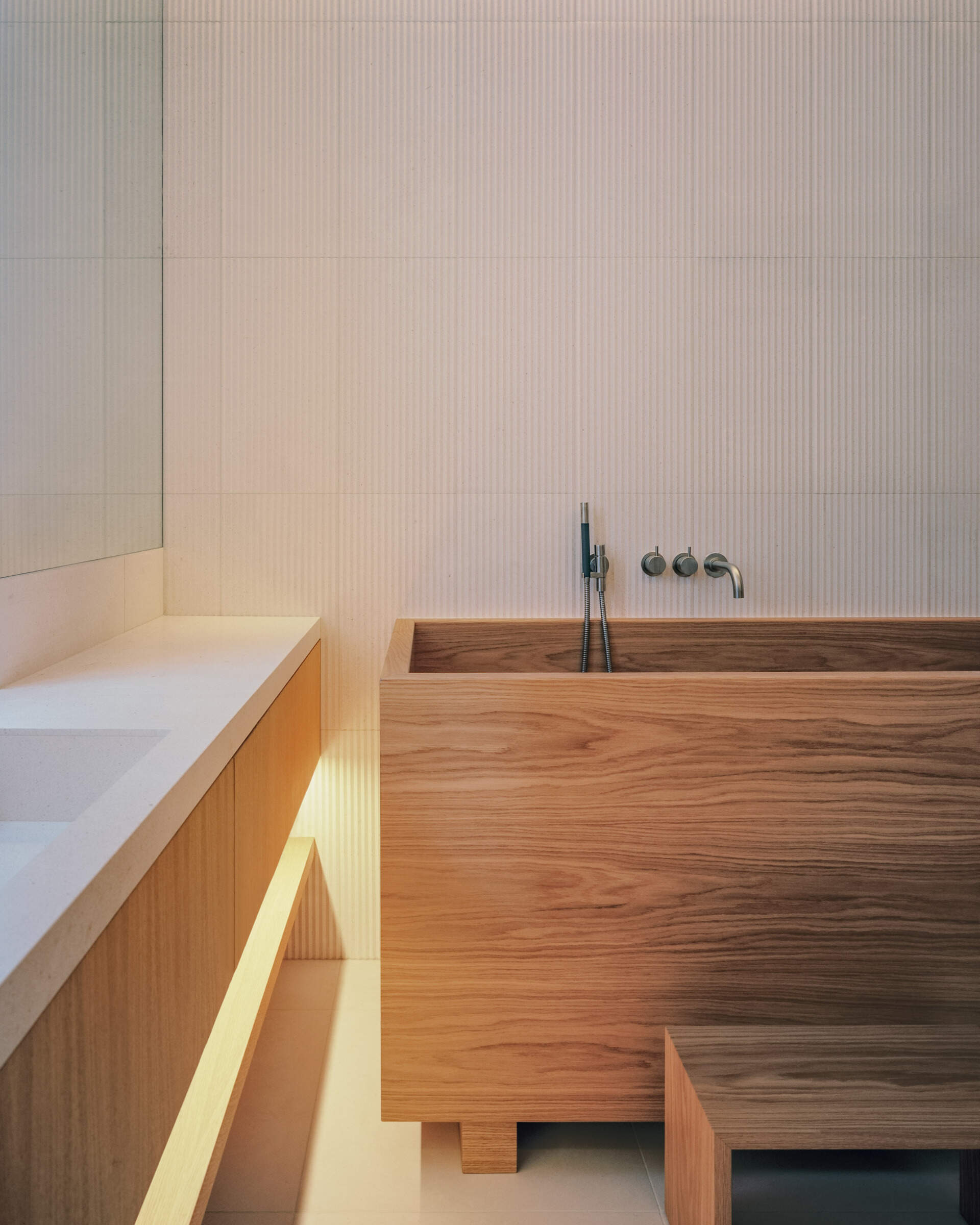 A private bedroom suite with an integrated office and a deep wood soaking tub blends function with standout design.